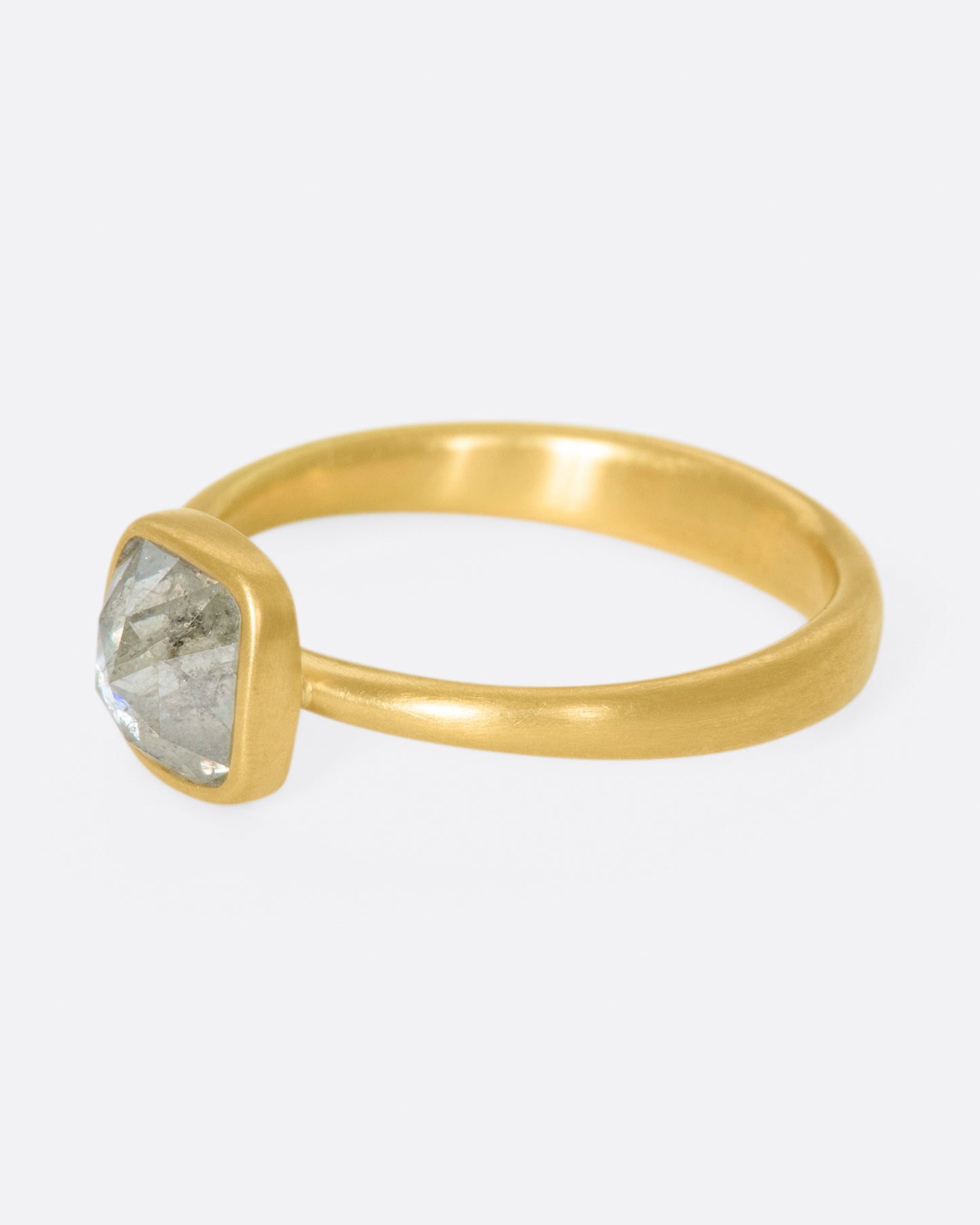 A faceted, cushion-shape diamond set in Lola Brooks' signature bezel setting