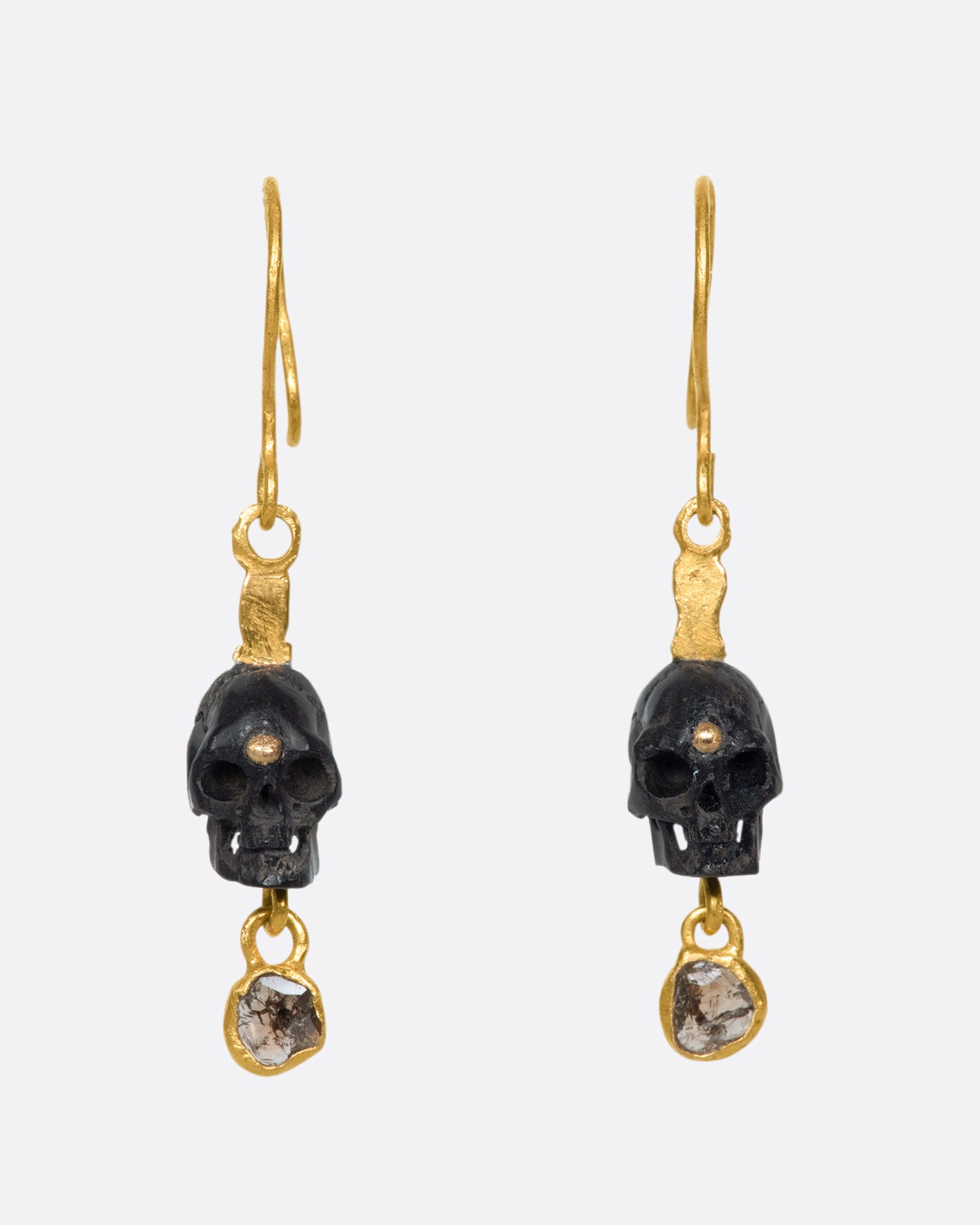 A pair of teeny, hand carved skulls with diamond dangles from Borneo.