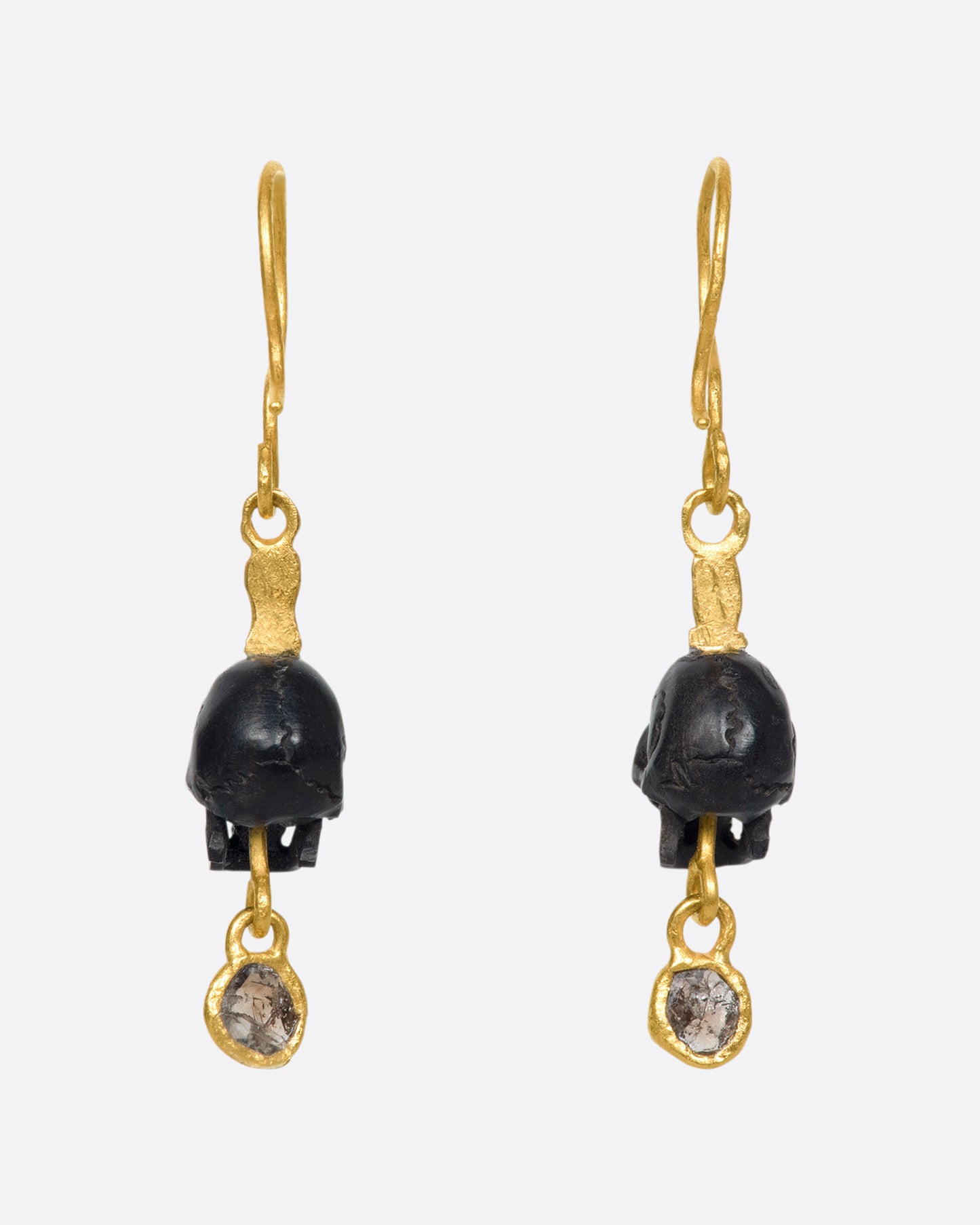 A pair of teeny, hand carved skulls with diamond dangles from Borneo.