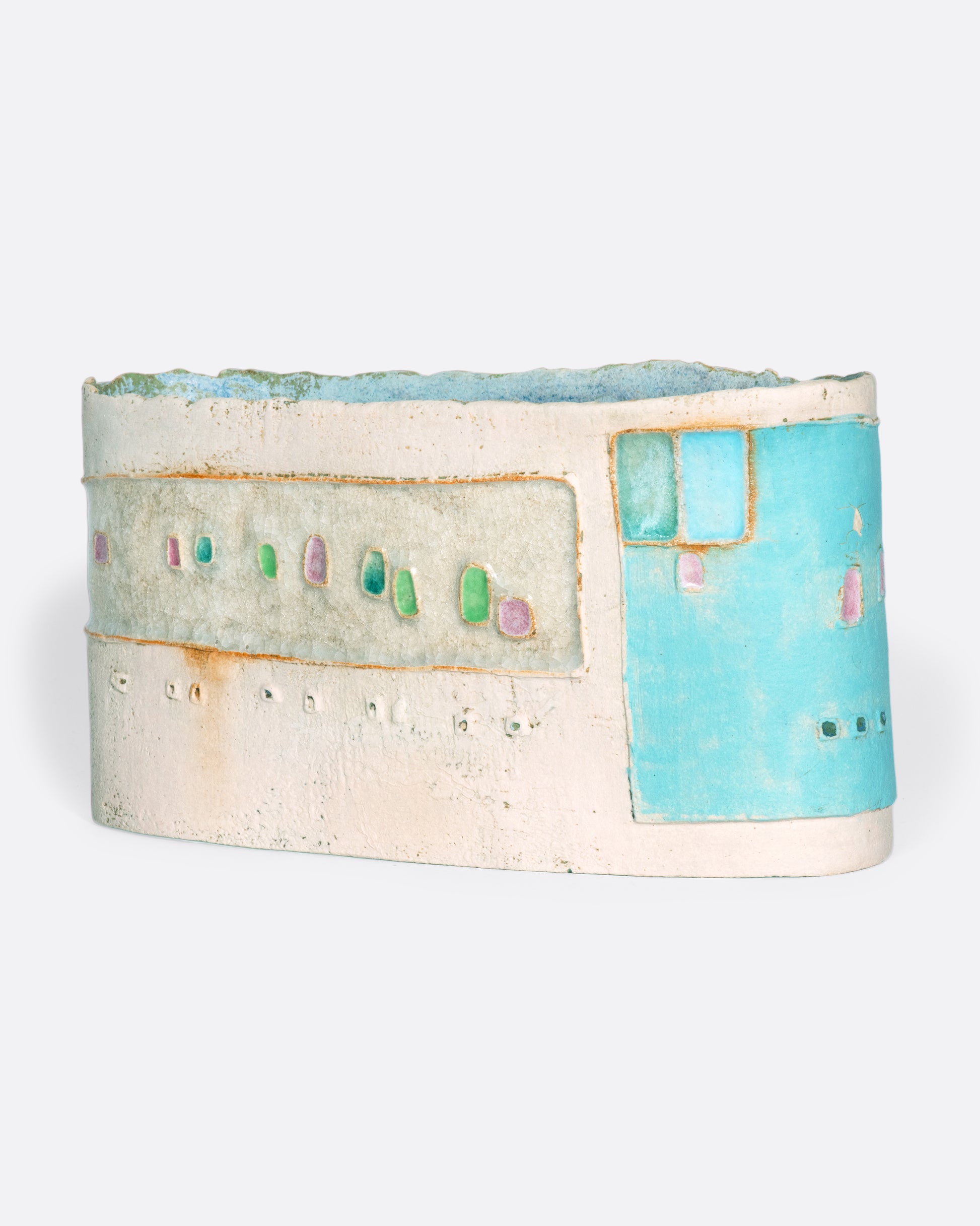 A ceramic vessel meticulously handmade with many layers of glaze atop stoneware clay. The rich, varied texture becomes a beautiful canvas for a dreamy slice of a sun-drenched town in Greece.