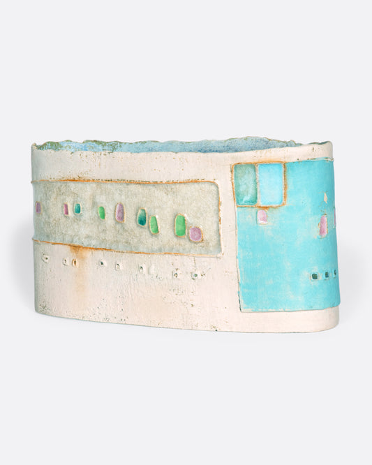 A ceramic vessel meticulously handmade with many layers of glaze atop stoneware clay. The rich, varied texture becomes a beautiful canvas for a dreamy slice of a sun-drenched town in Greece.