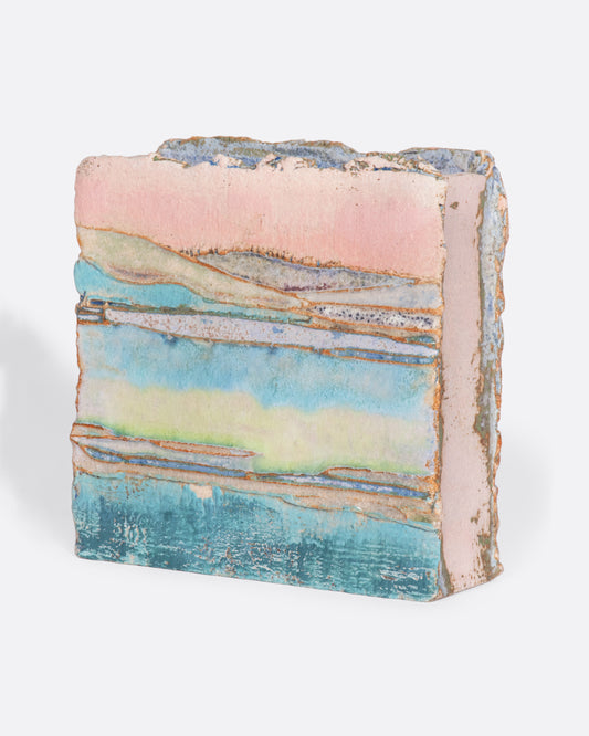 A ceramic vessel meticulously handmade with many layers of glaze atop stoneware clay. The rich, varied texture becomes a beautiful canvas for an ethereal landscape like you're gazing over a lake while the sunsets golden over hills in the distance.