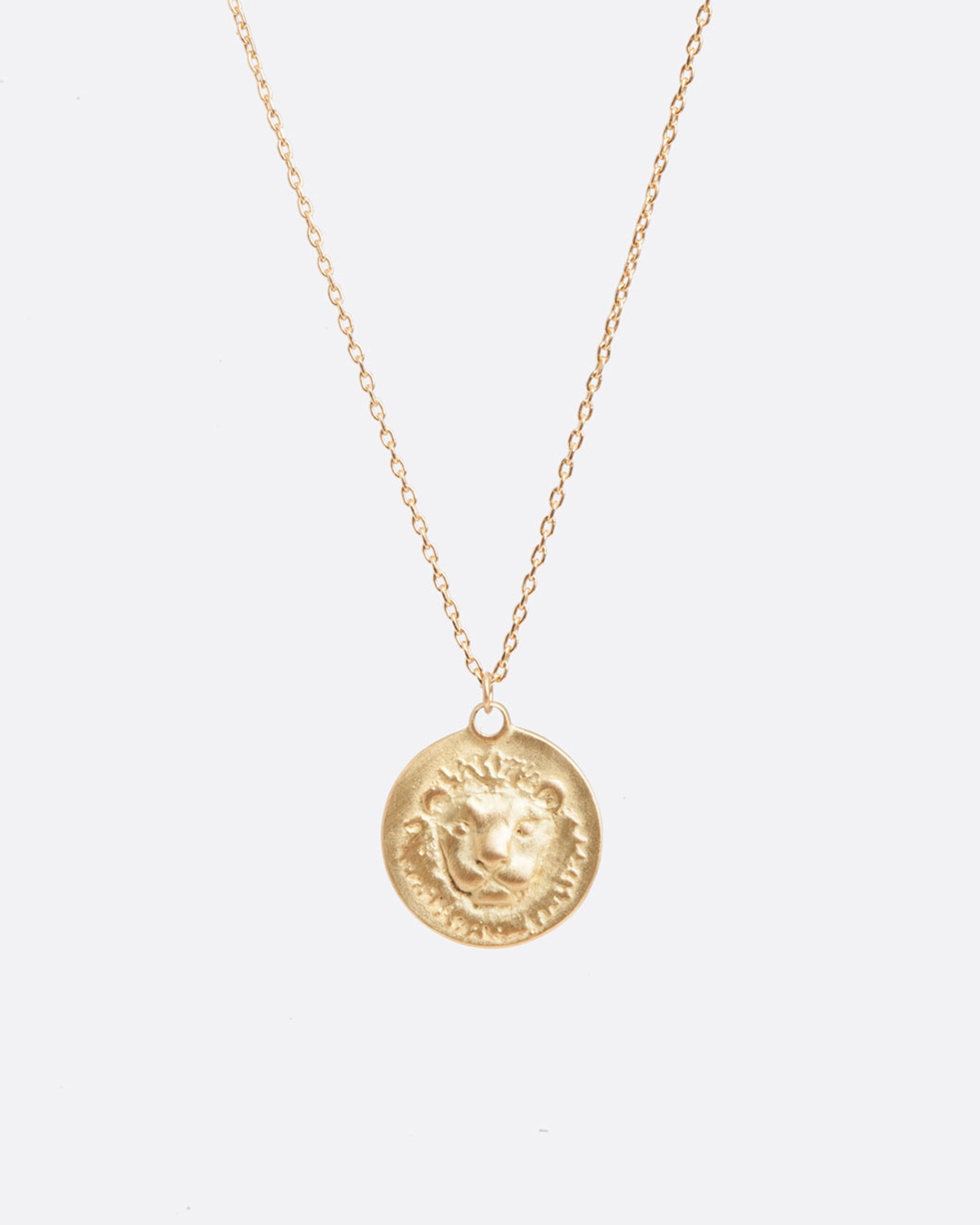 A yellow gold necklace with a round pendant with your choice of zodiac symbol.