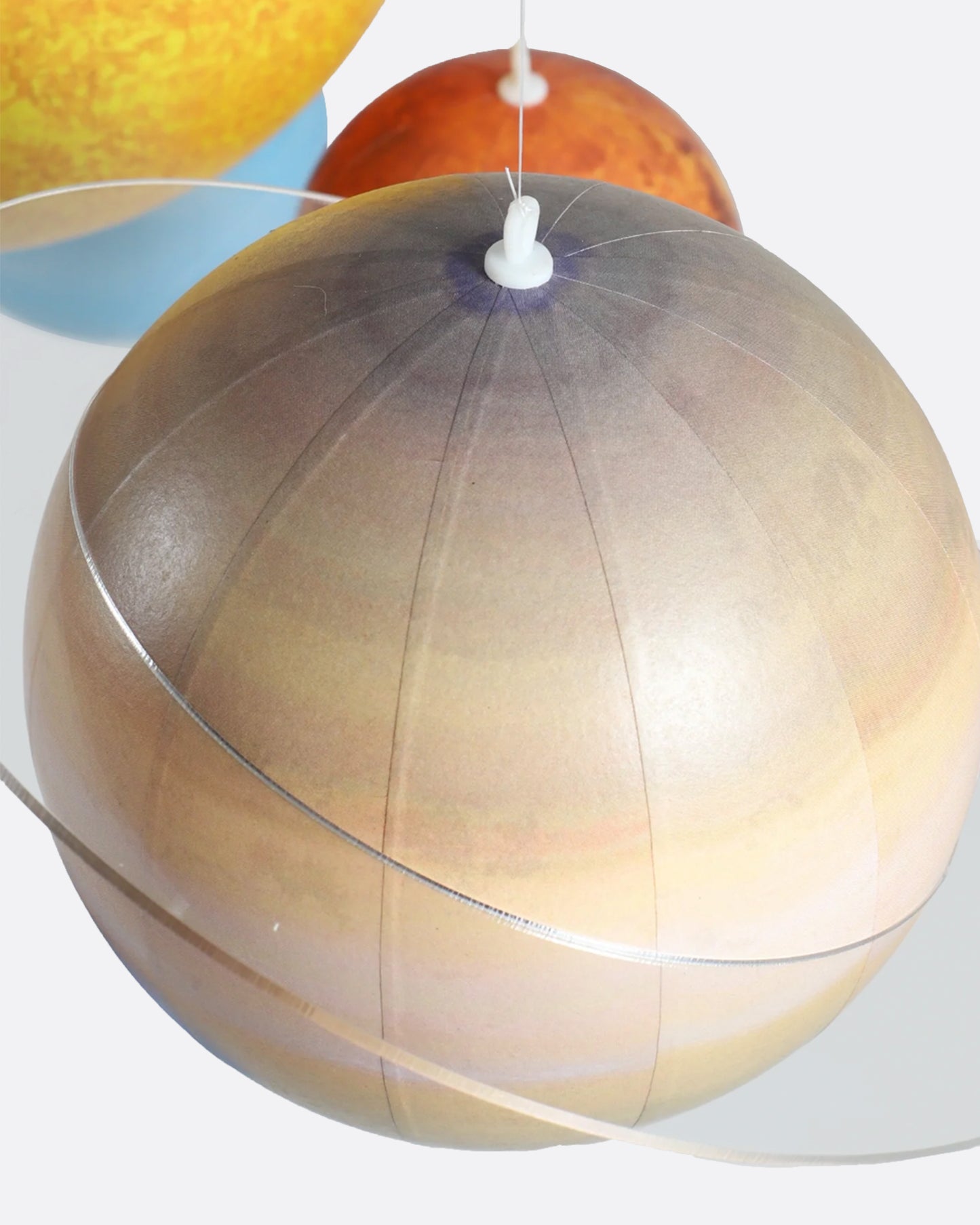 A hanging mobile with each of the planets and the sun in our solar system. Shown close up.