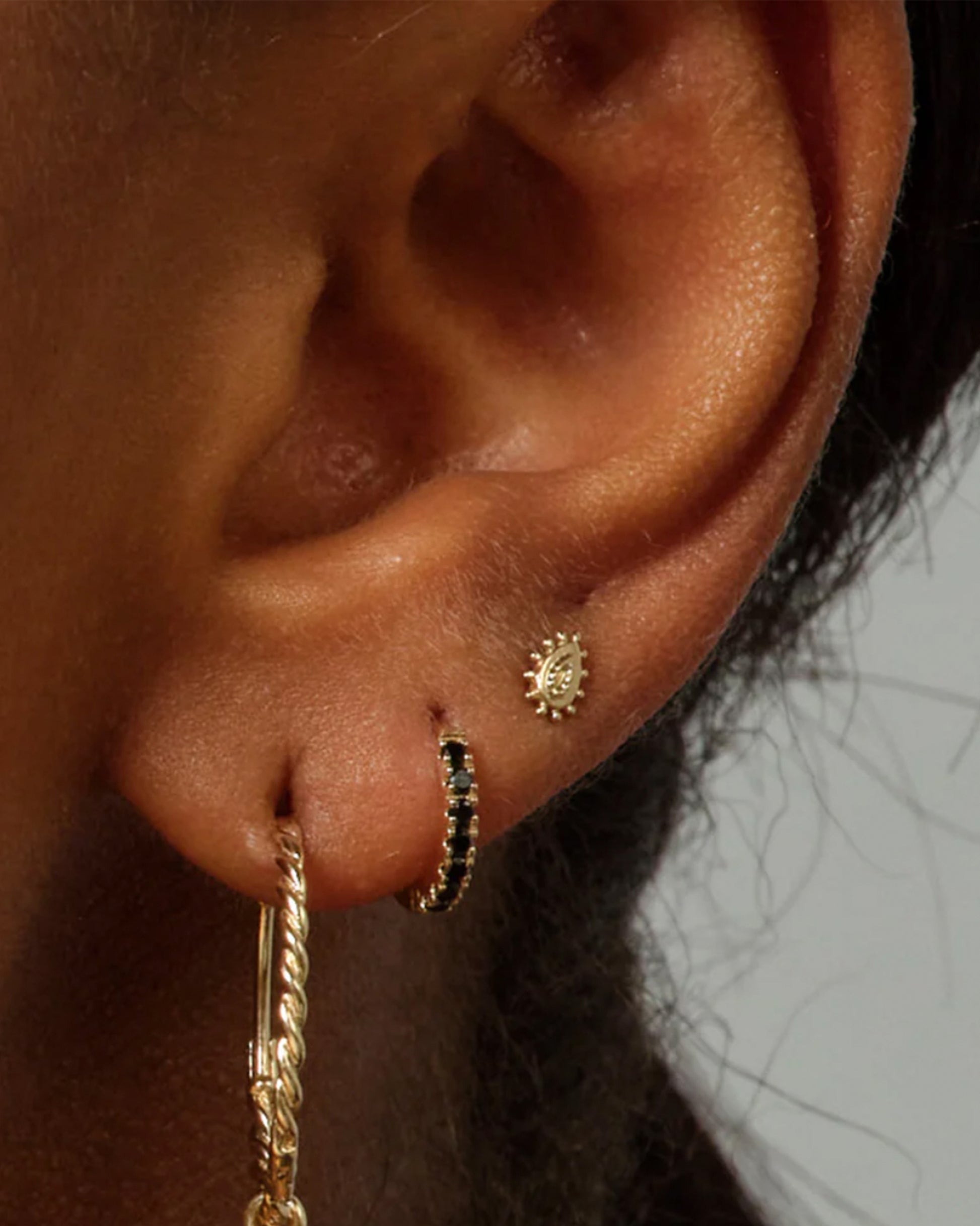 A small, hinged hoop lined with deep blue sapphires.