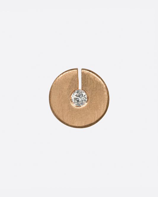 This disc stud has a diamond at its center, made even more dazzling by the break in the circle that allows light in.