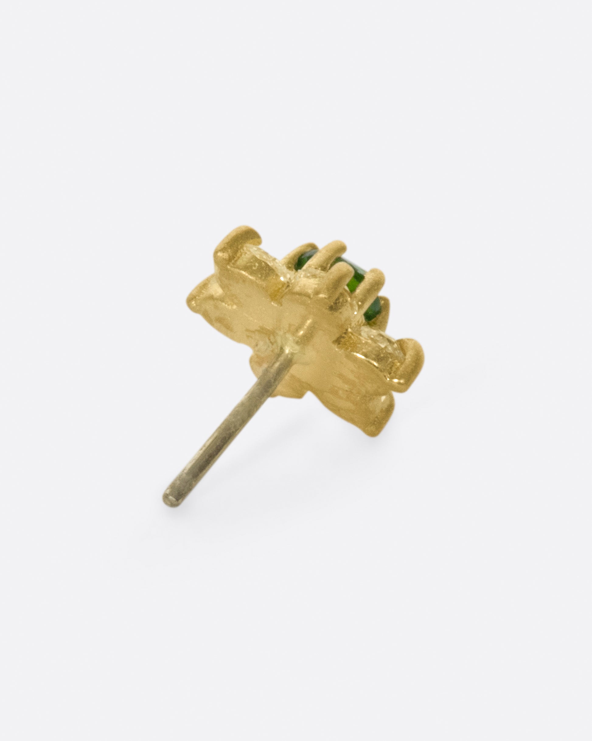 A yellow gold threadless earring front made from 6 white diamond and one green chrome diopside in the shape of a flower. Shown from the side.