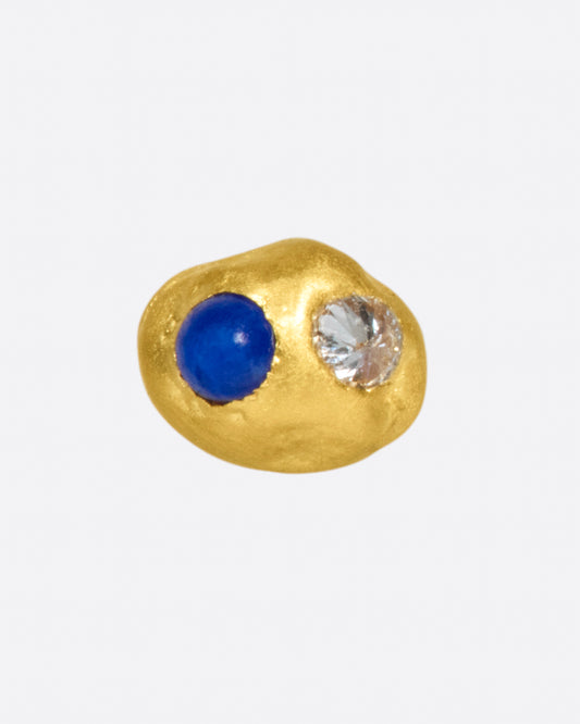 A high karat gold blob threadless earring with one lapis cabochon and one reverse-set white diamond.