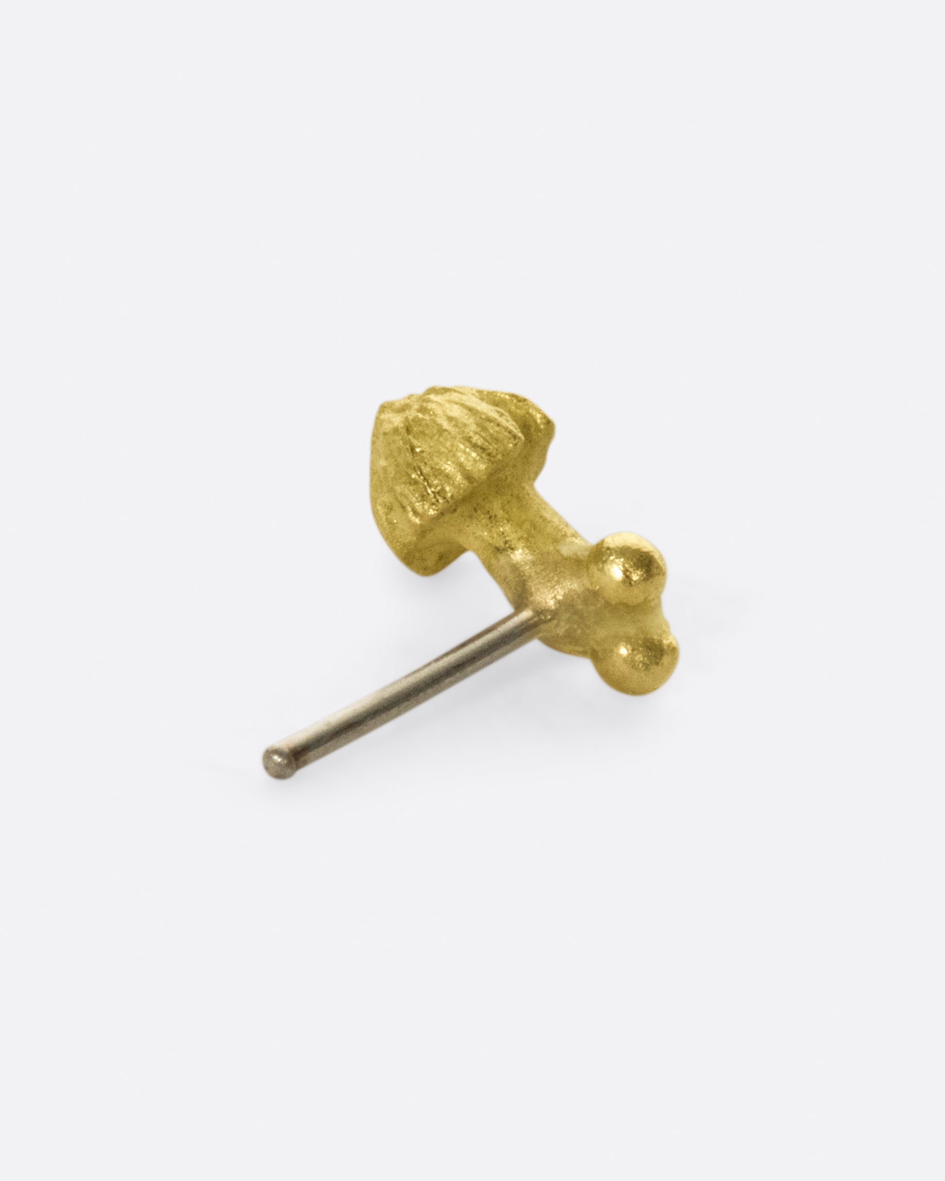 A small, matte gold, hand carved mushroom.