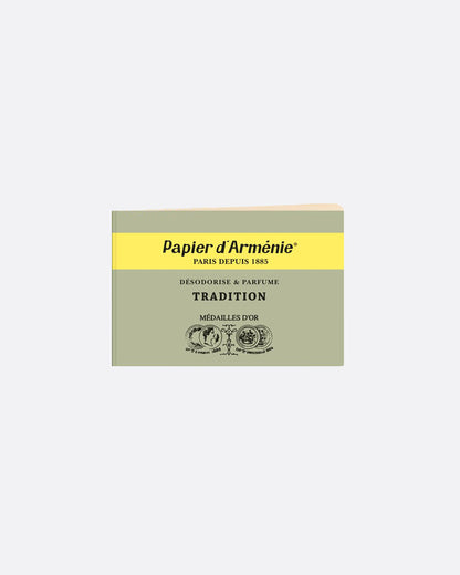 A green and yellow booklet of paper incense. The front reads: 'Paper d'Arménie PARIS DEPUIS 1885 DÉSODORISE & PARFUME TRADITION MÉDAILLE D'OR' and has medallion imagery at the bottom. Shown from the front.
