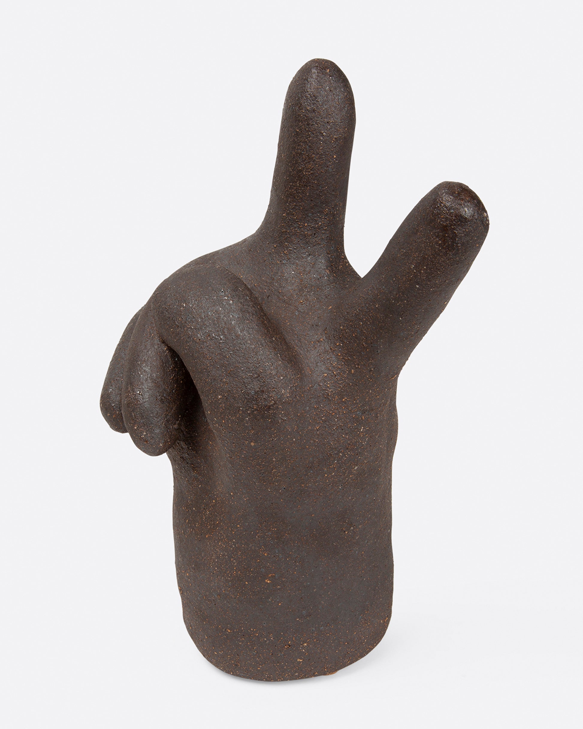 A large, dark brown peace hand sculpture, shown from the side.