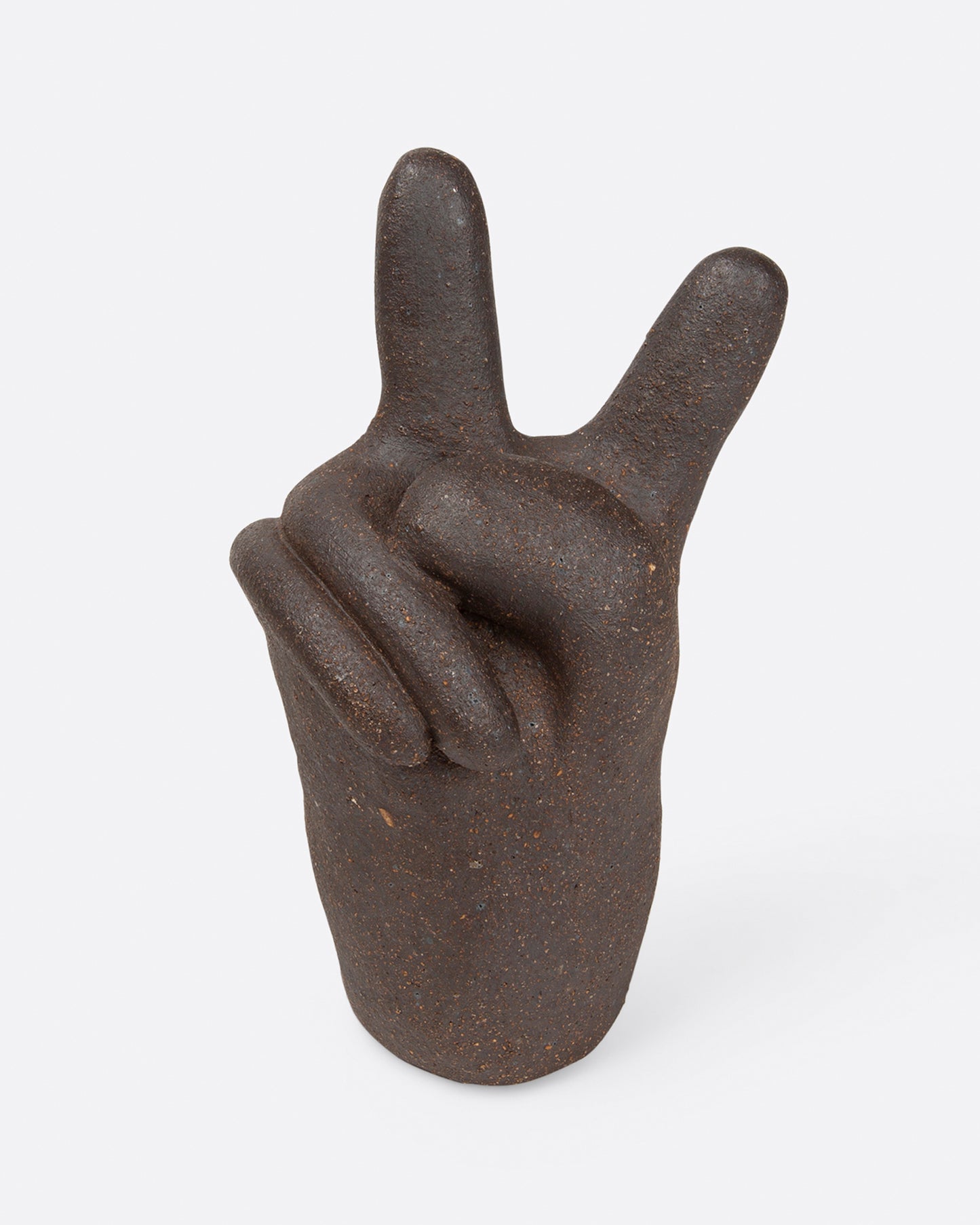 A small, dark brown peace hand sculpture, shown from the front.