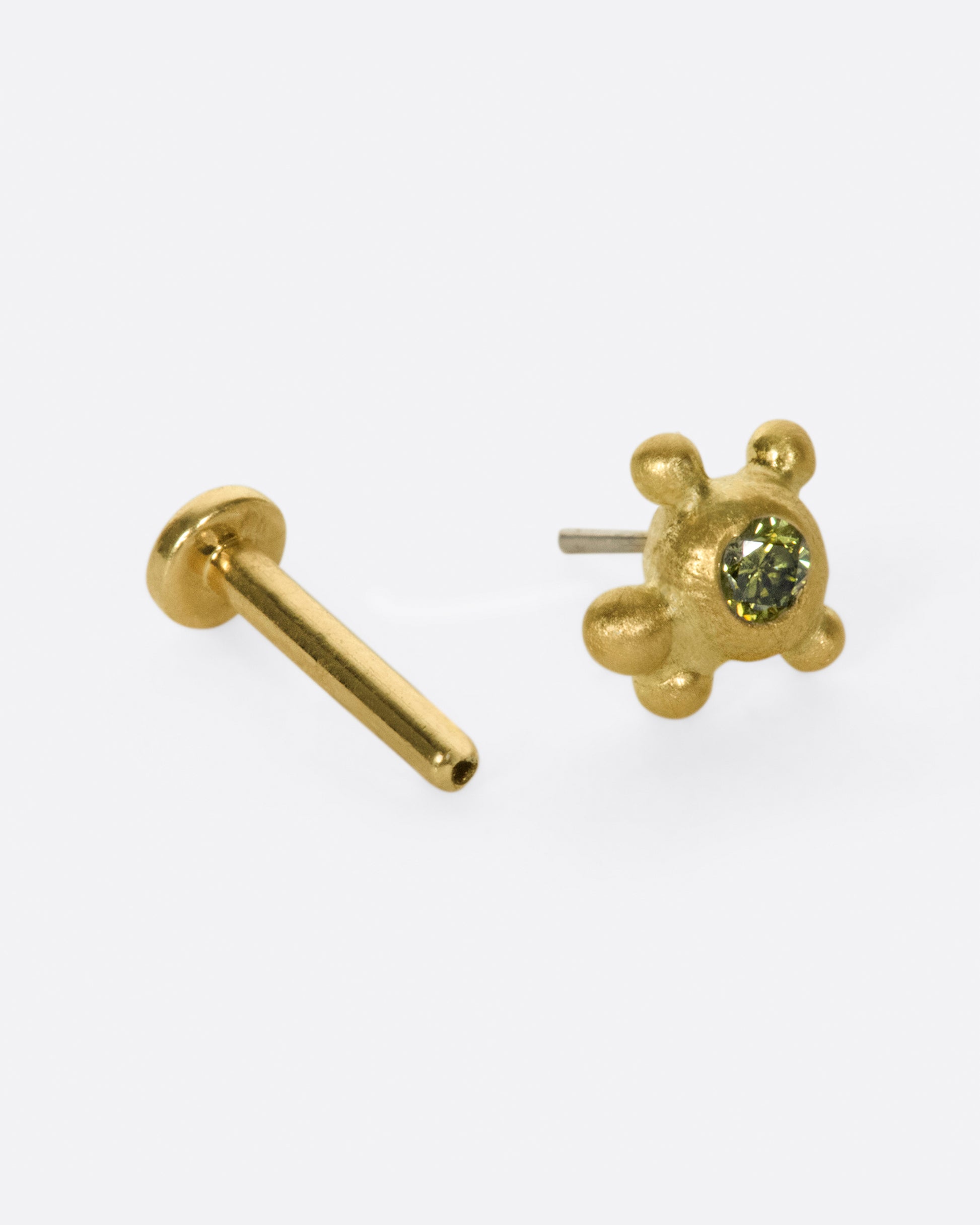 No two of these cluster studs is exactly the same; this time with four granules and an olive green diamond.