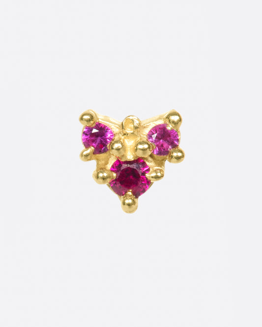 A textured arrow earring with three rosy rubies.