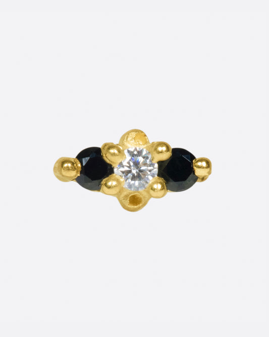 Two intense black spinels bookend a luminous white sapphire in this classic trio setting.