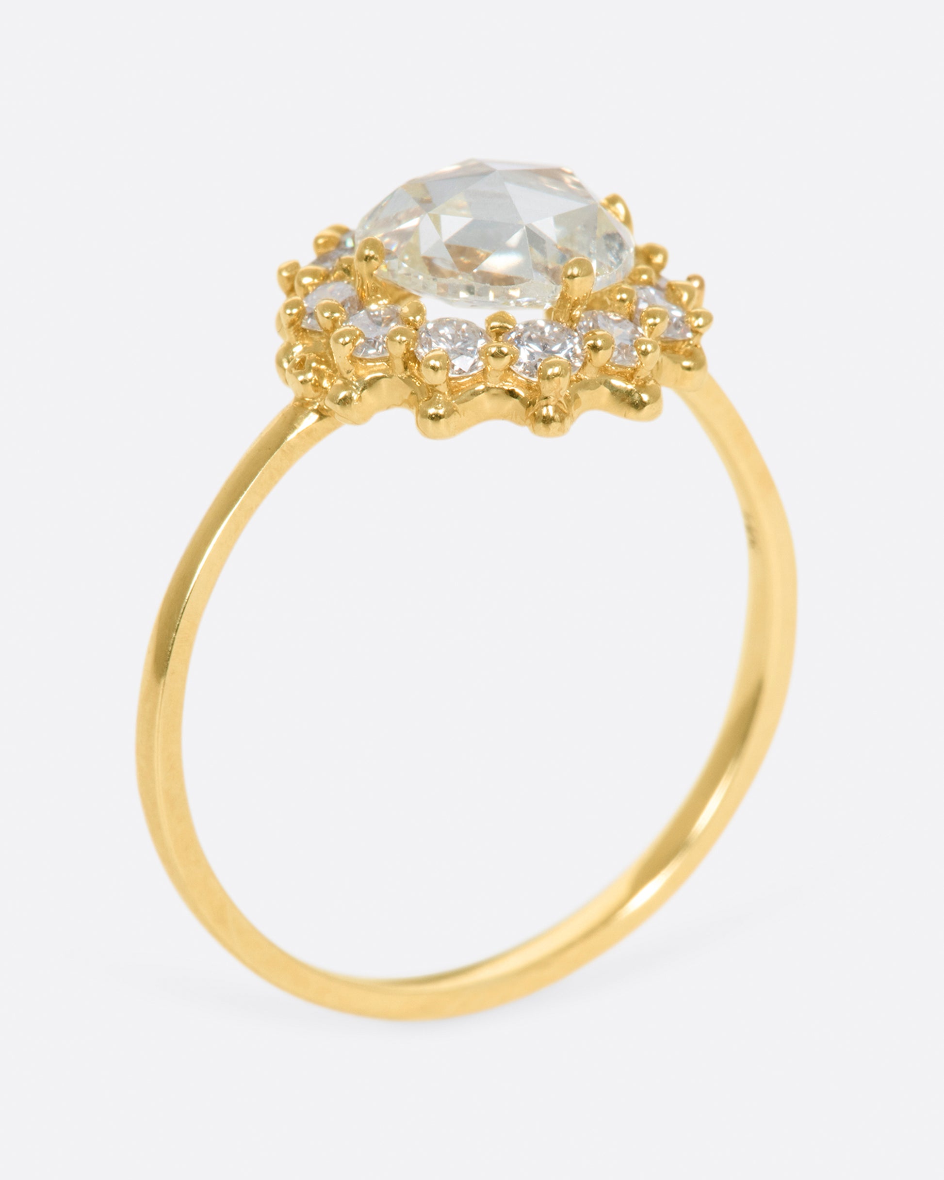 This light champagne, rose cut diamond is surrounded by a diamond halo, giving it the illusion of a shining sun.