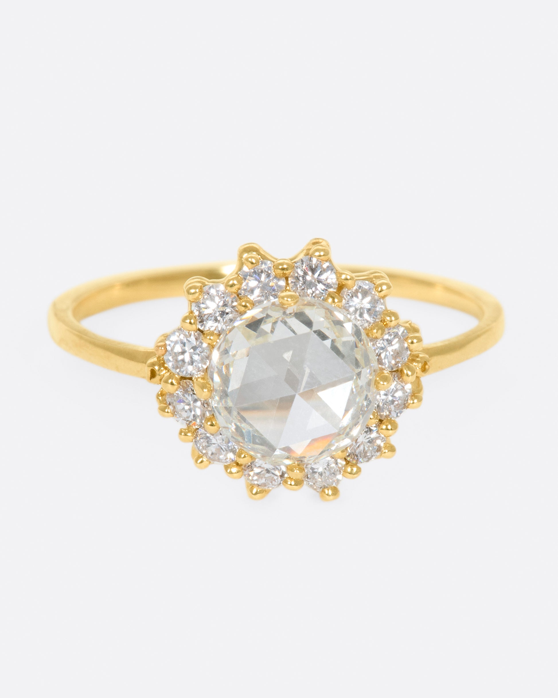 This light champagne, rose cut diamond is surrounded by a diamond halo, giving it the illusion of a shining sun.