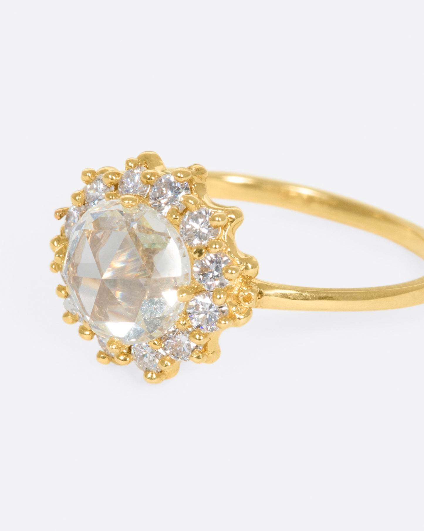 This light champagne, rose cut diamond is surrounded by a diamond halo, giving it the illusion of a shining sun.