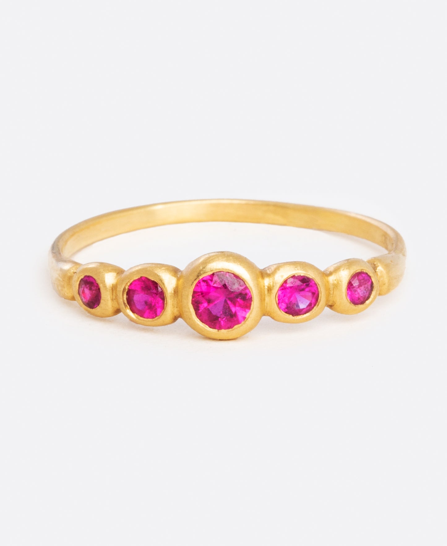 A classic combo, ruby and yellow gold, make up this ring with graduated sizes of stones.