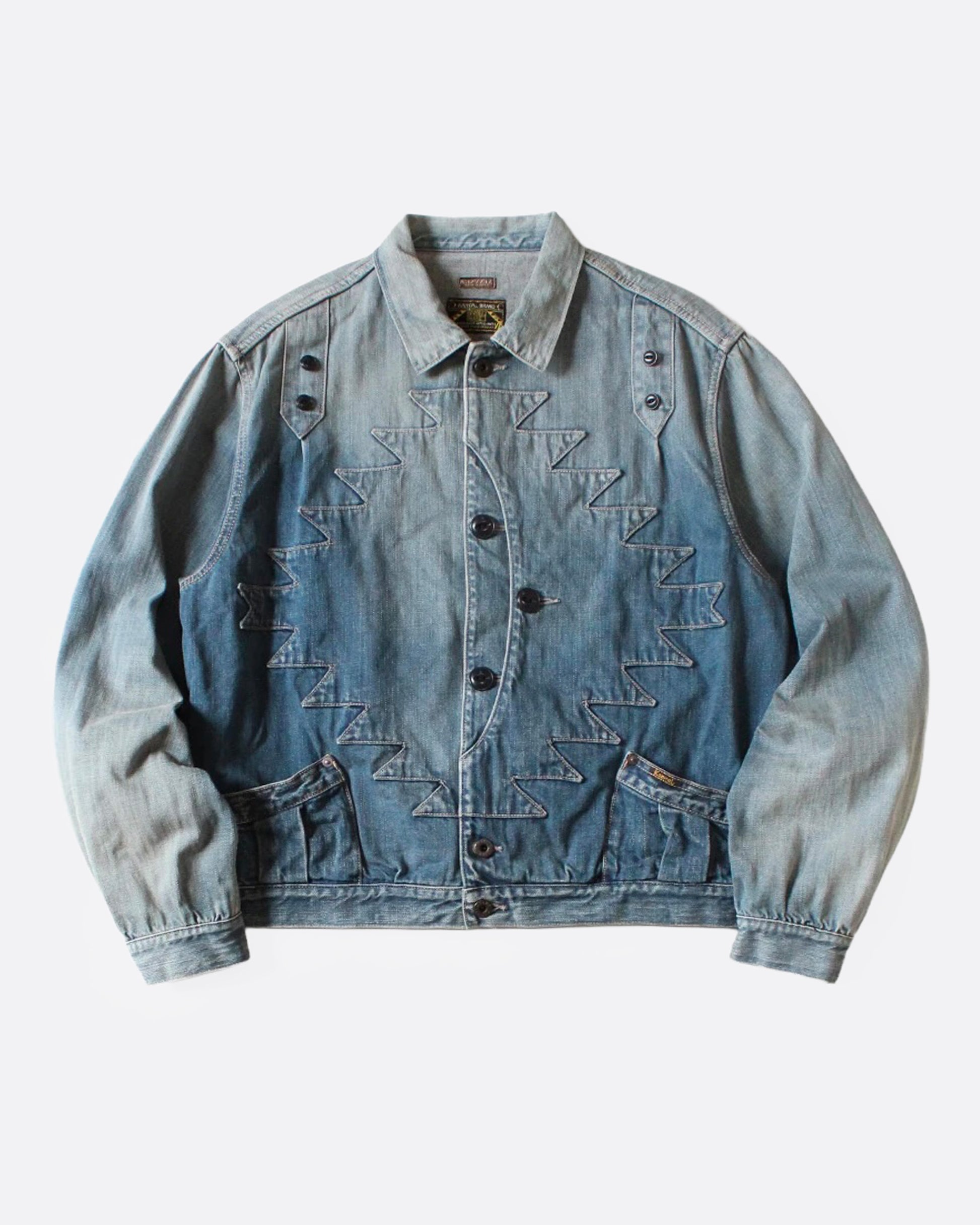 A light blue denim jacket with Chimayo-inspired embroidery across the chest and at each elbow, button closures, and functional back cinch. Shown from the front.