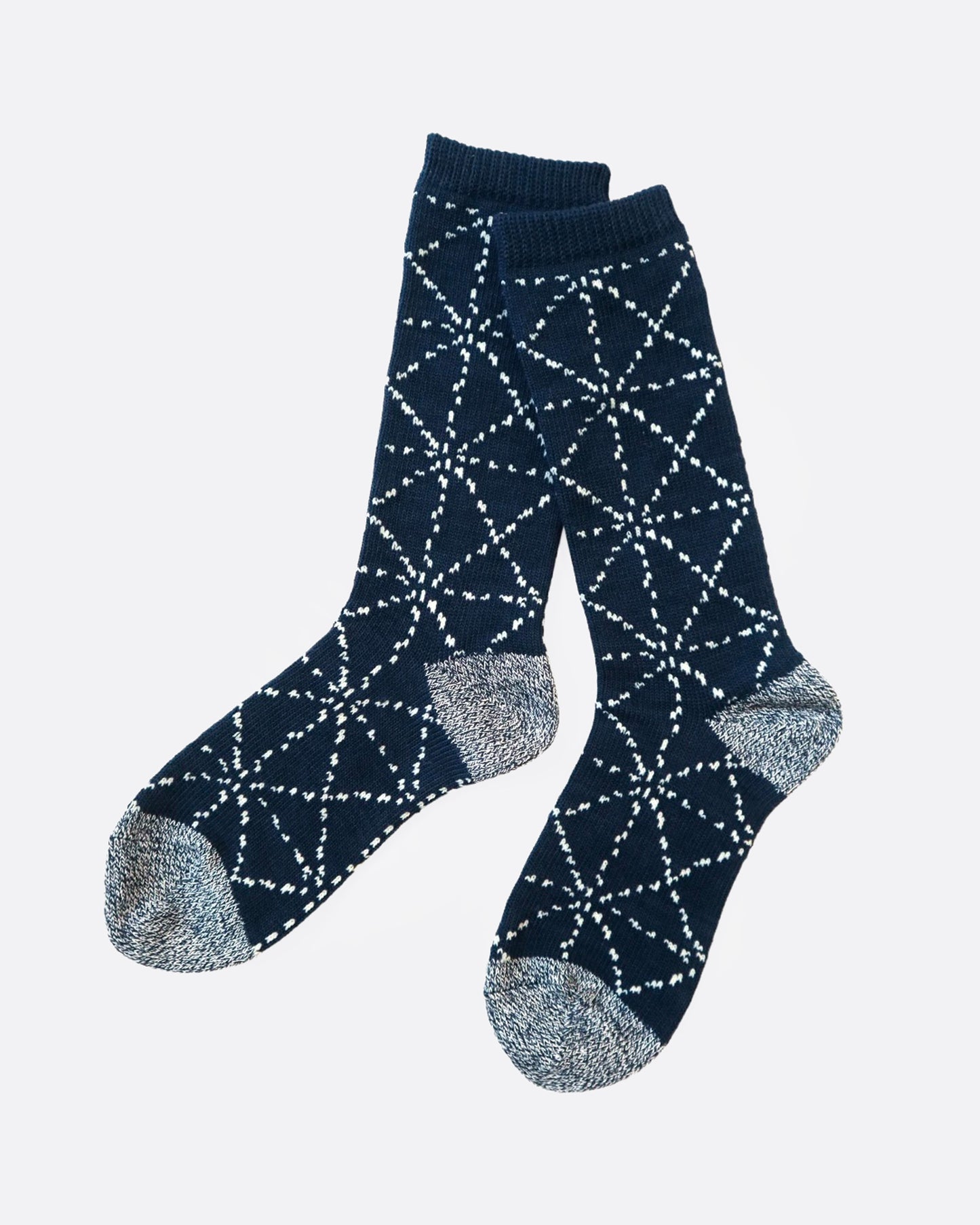 A pair of navy blue socks with a Japanese sashiko print, shown from the side.