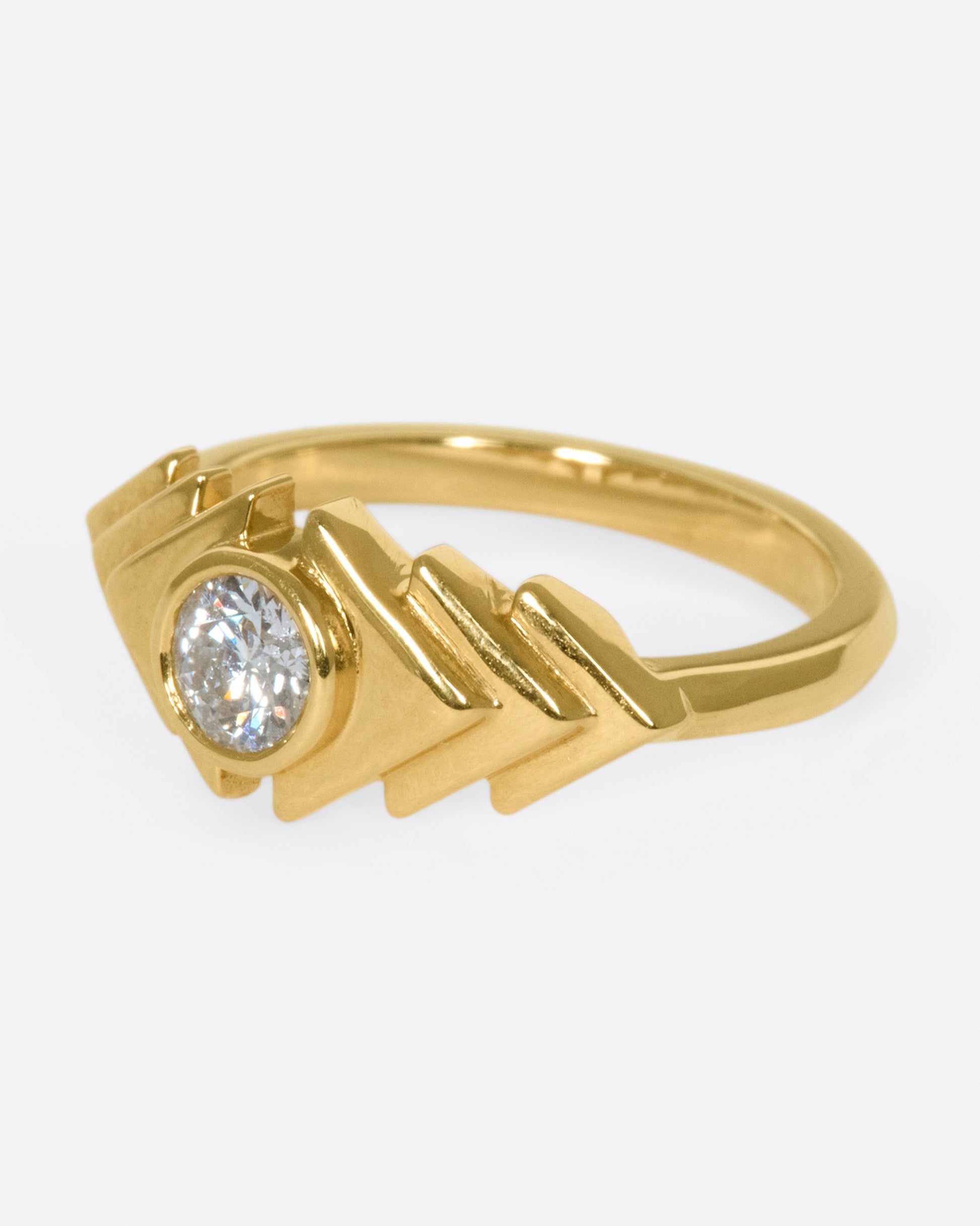 This ring takes cues from tribal kilim pieces, featuring a round diamond contrasting with a repetitive triangular motif