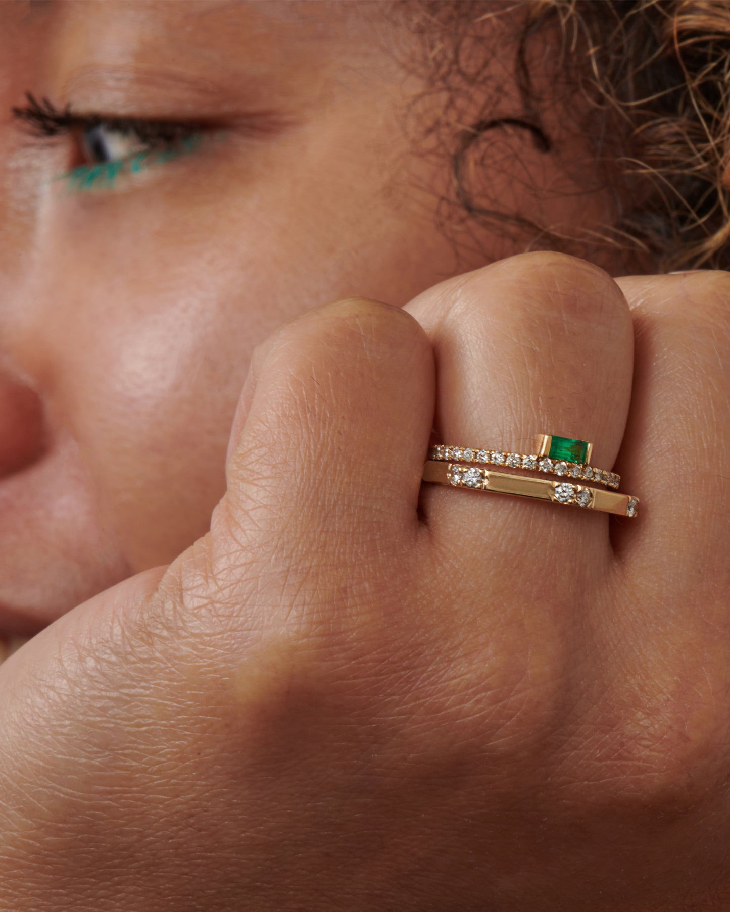 A partially pavé diamond band with an emerald baguette