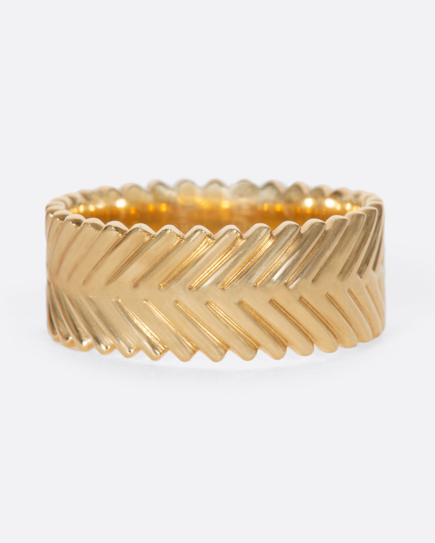 A yellow gold band ring with a braid-like texture, by Selin Kent.