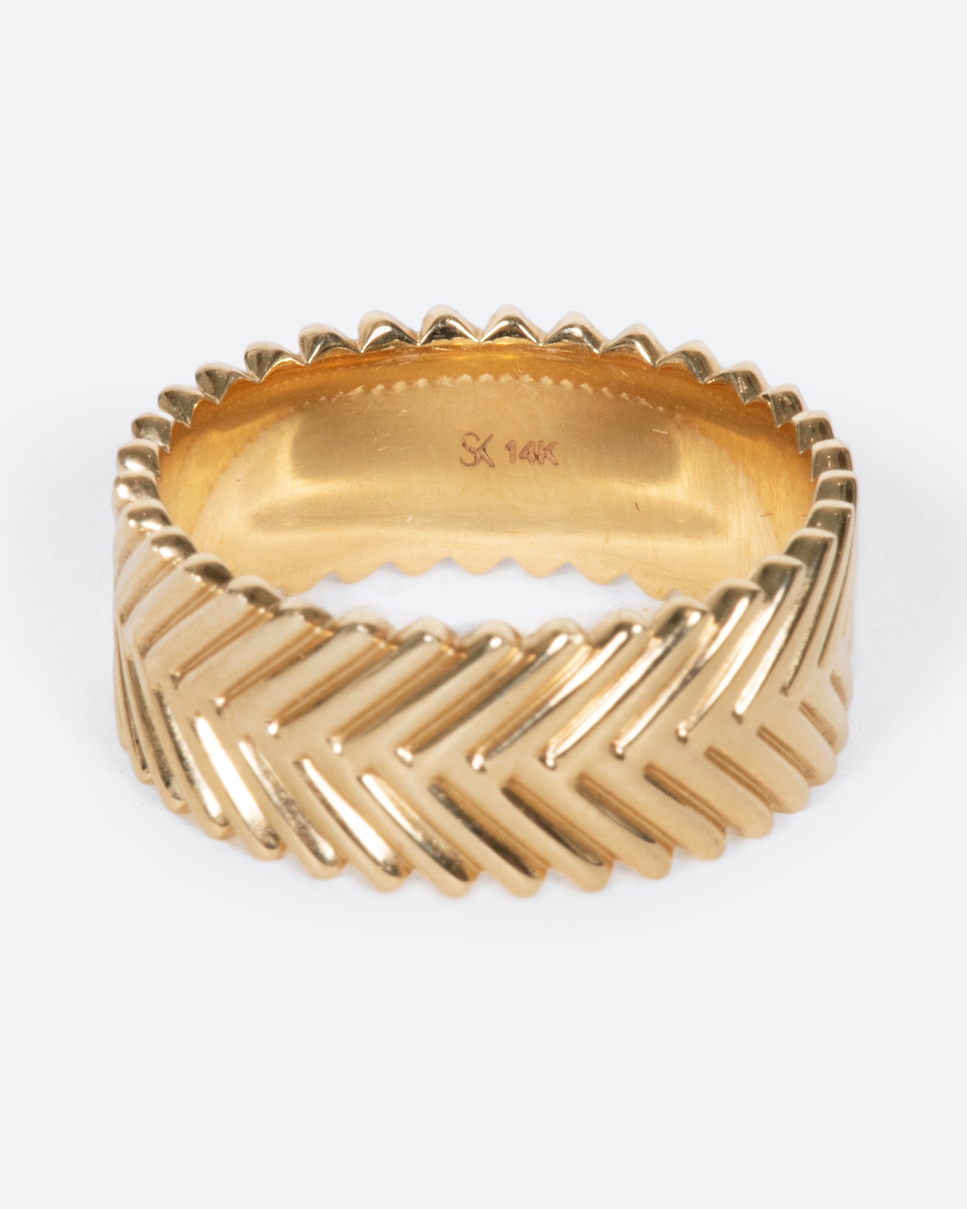 A yellow gold band ring with a braid-like texture, by Selin Kent.