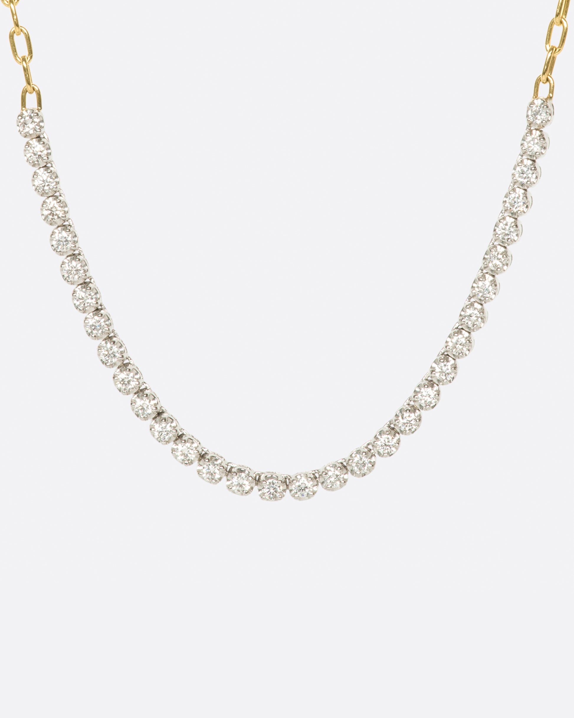 A yellow gold, oval link, chain necklace with four inches of contrasting white diamonds