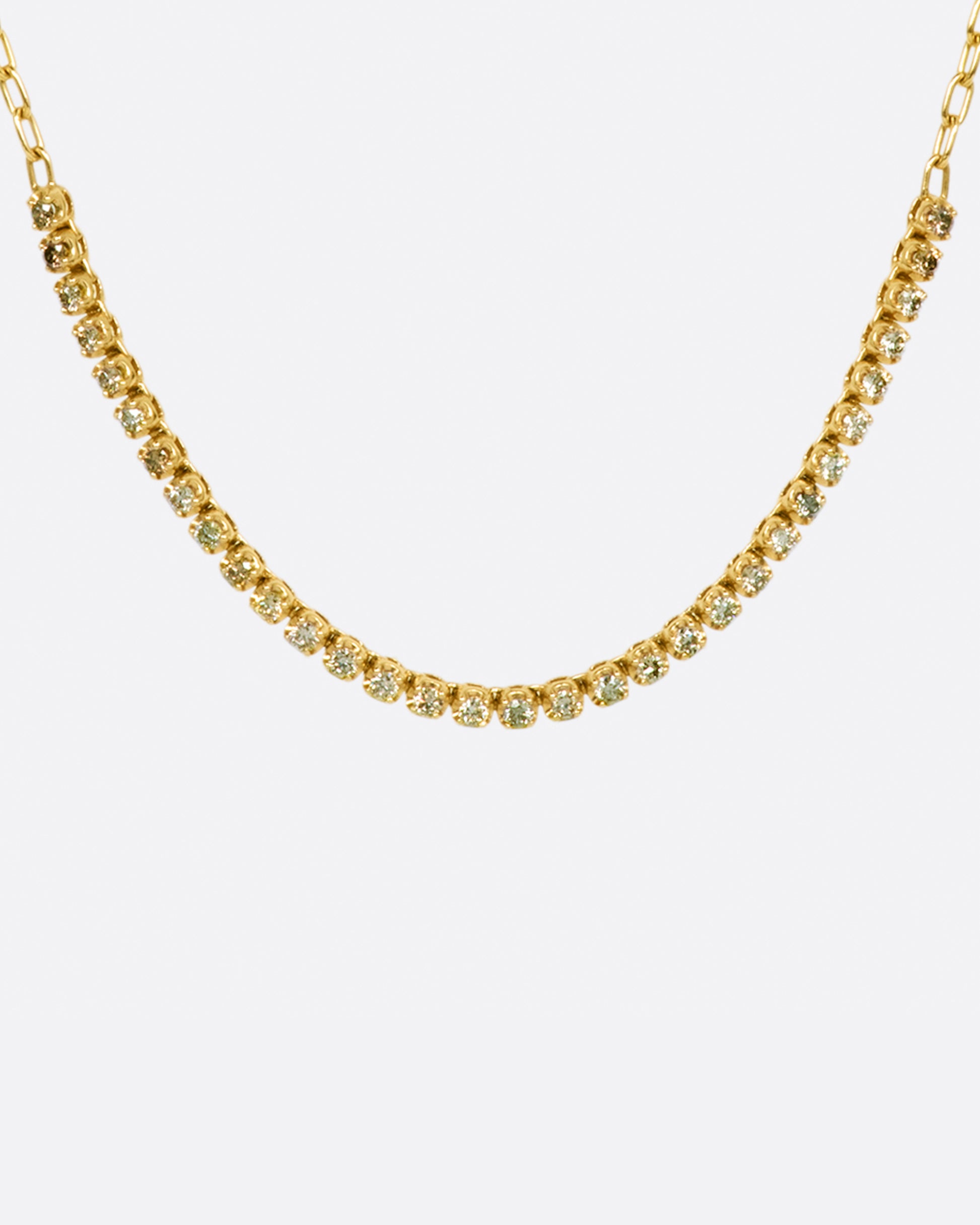 A yellow gold chain necklace with a section of green, champagne and cognac diamonds along the front.