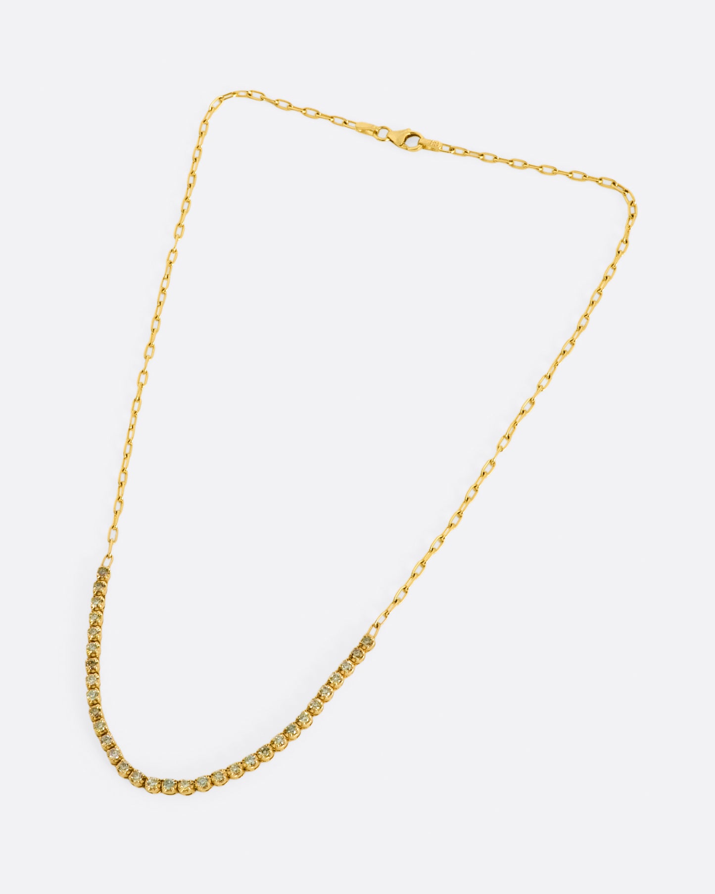 A yellow gold chain necklace with a section of green, champagne and cognac diamonds along the front.