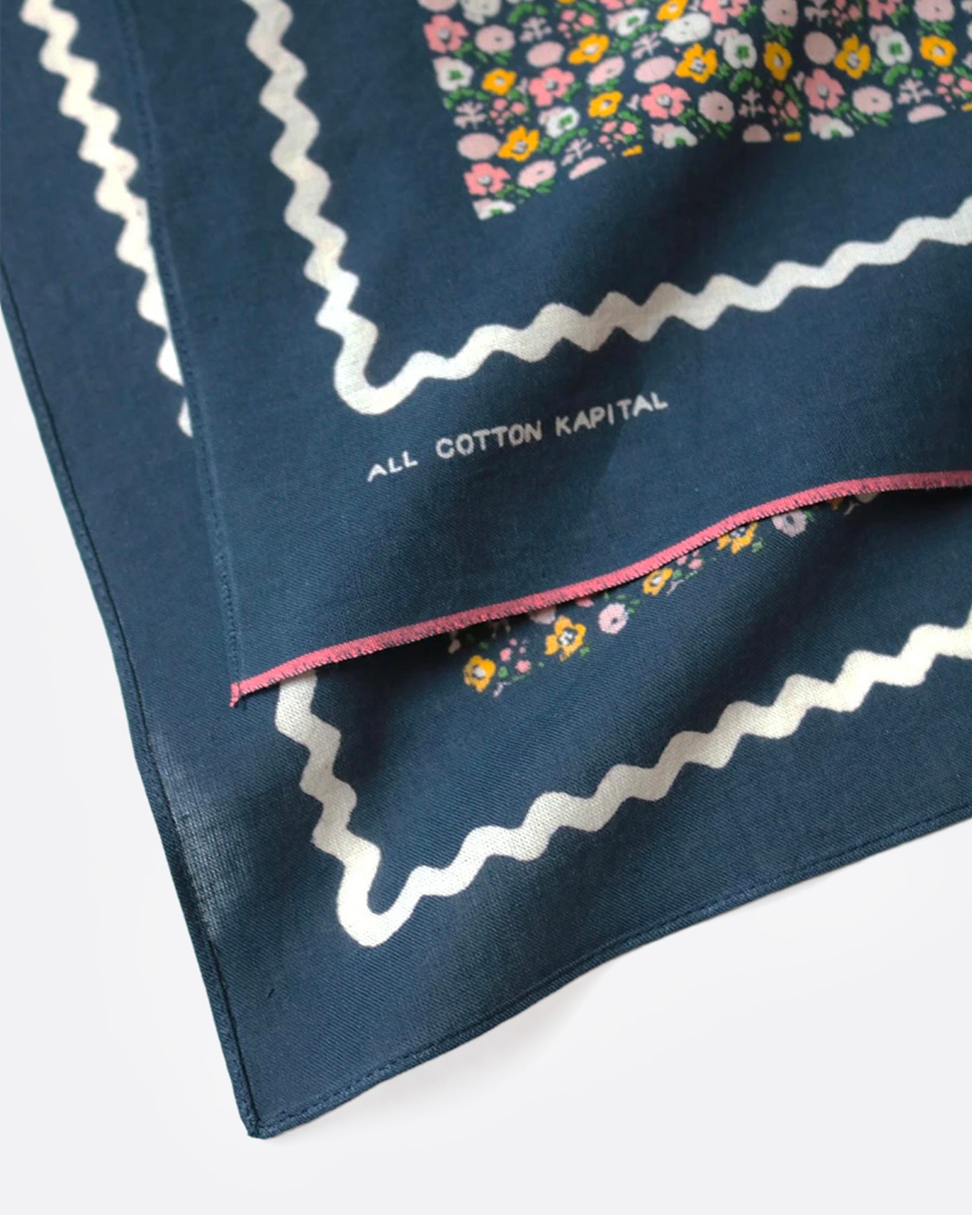 A close up of a navy blue bandana with a ditsy floral print and tiny skulls throughout.