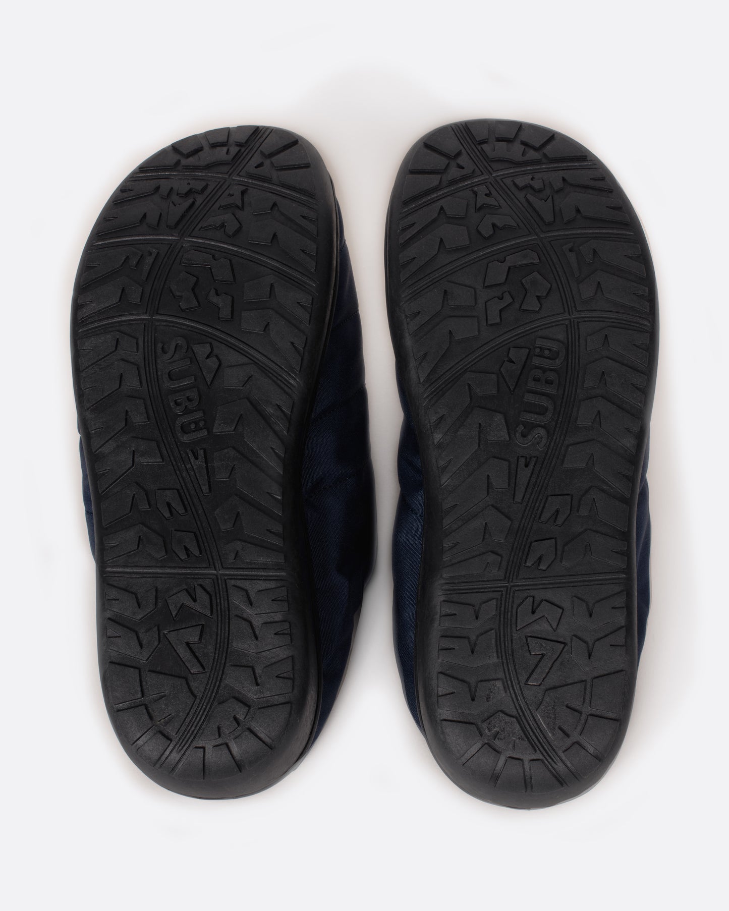 A pair of navy nylon slippers with black rubber soles, shown from the underside.