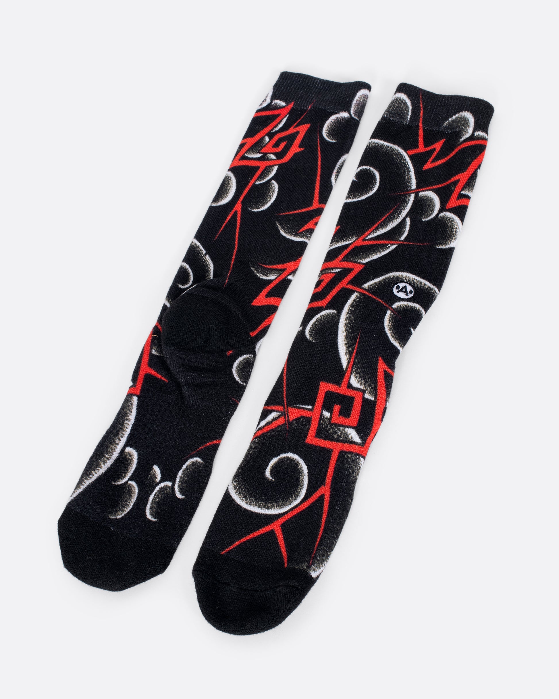 Black socks with white and red rounded and geometric swirl patterns. View from the front and alternating back.