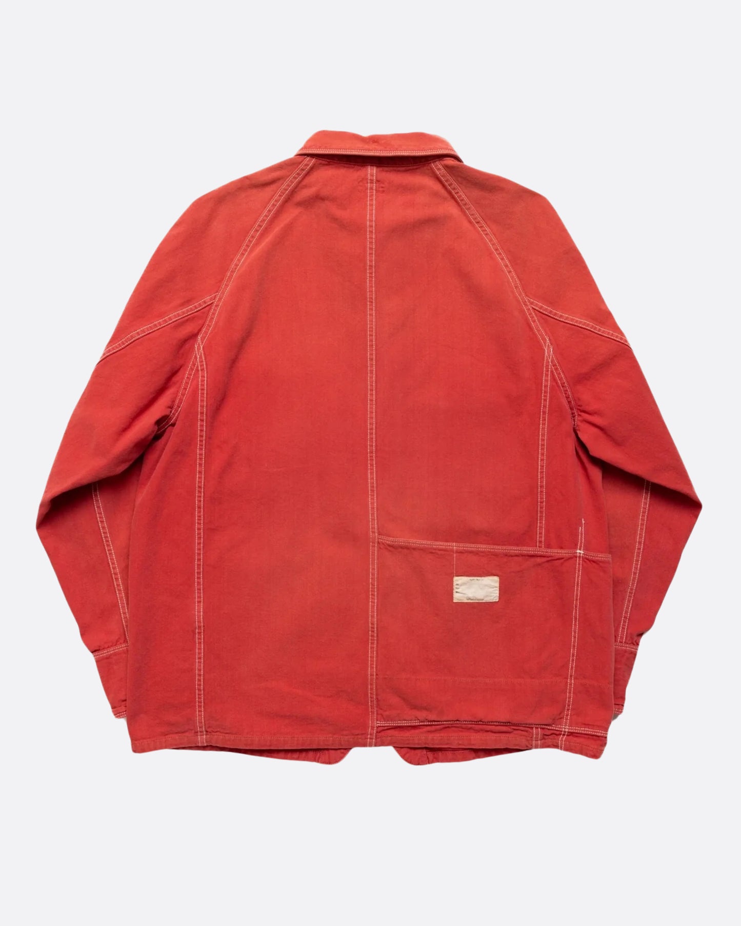 A red canvas chore coat with four front pockets. View of the back.