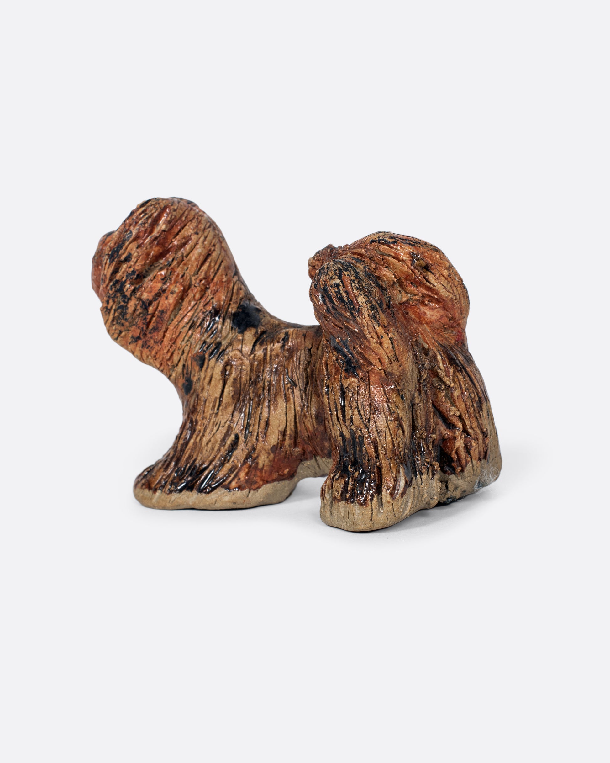 A handmade ceramic dog sculpture. Shown from the back.