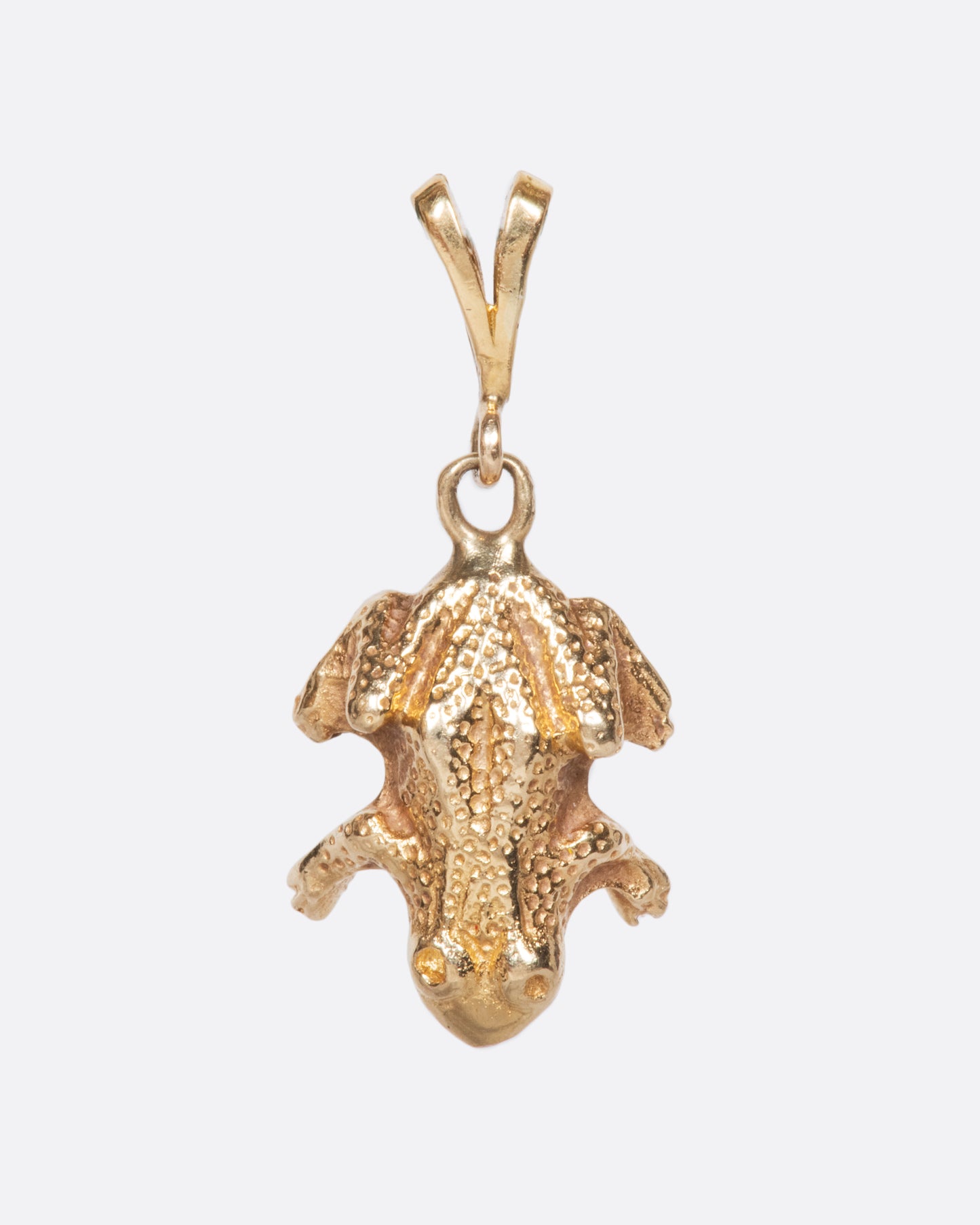 A yellow gold vintage frog charm with incredible detail and texture.