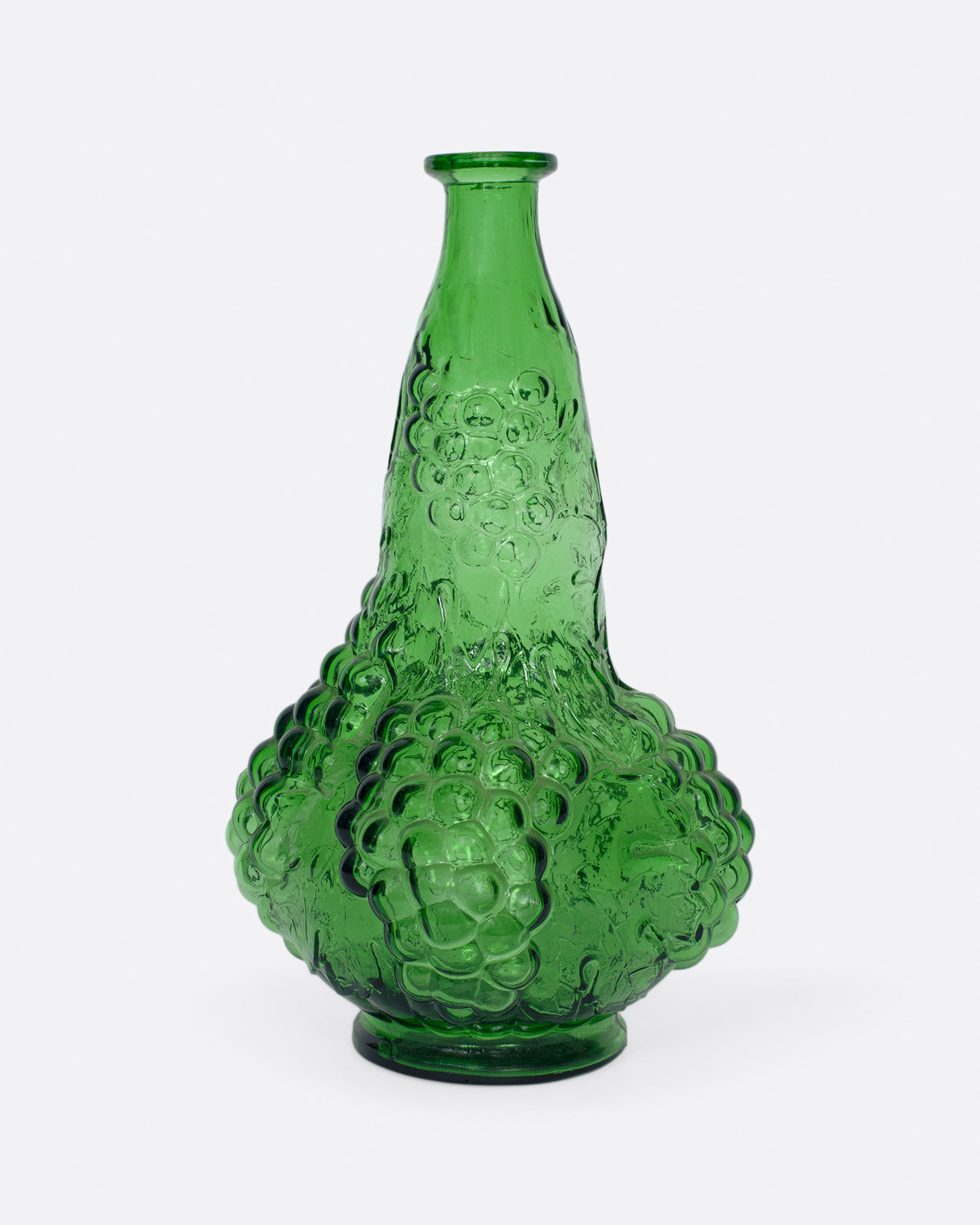 A tall, bottle green glass decanter with a textured stopper.