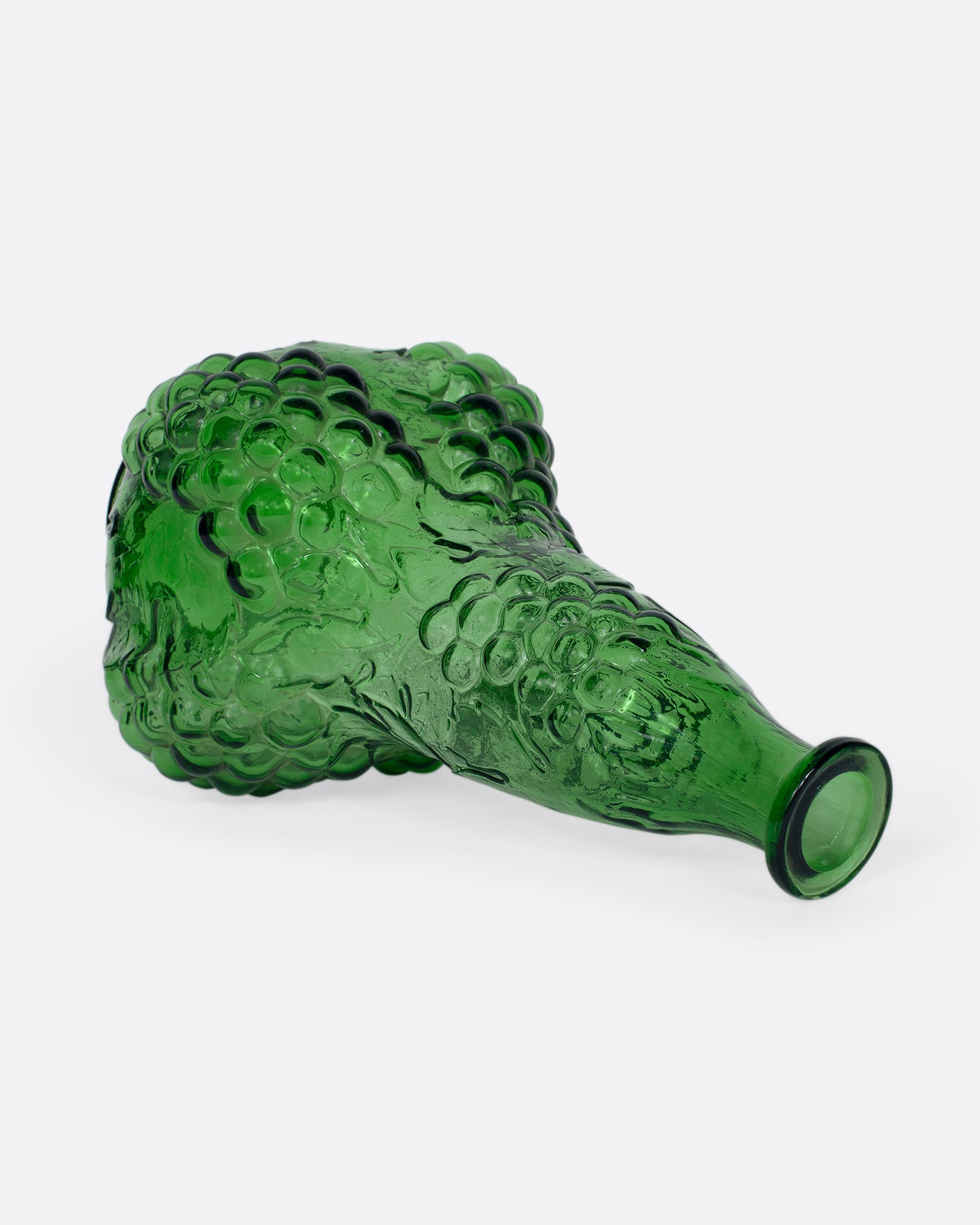 A tall, bottle green glass decanter with a textured stopper.