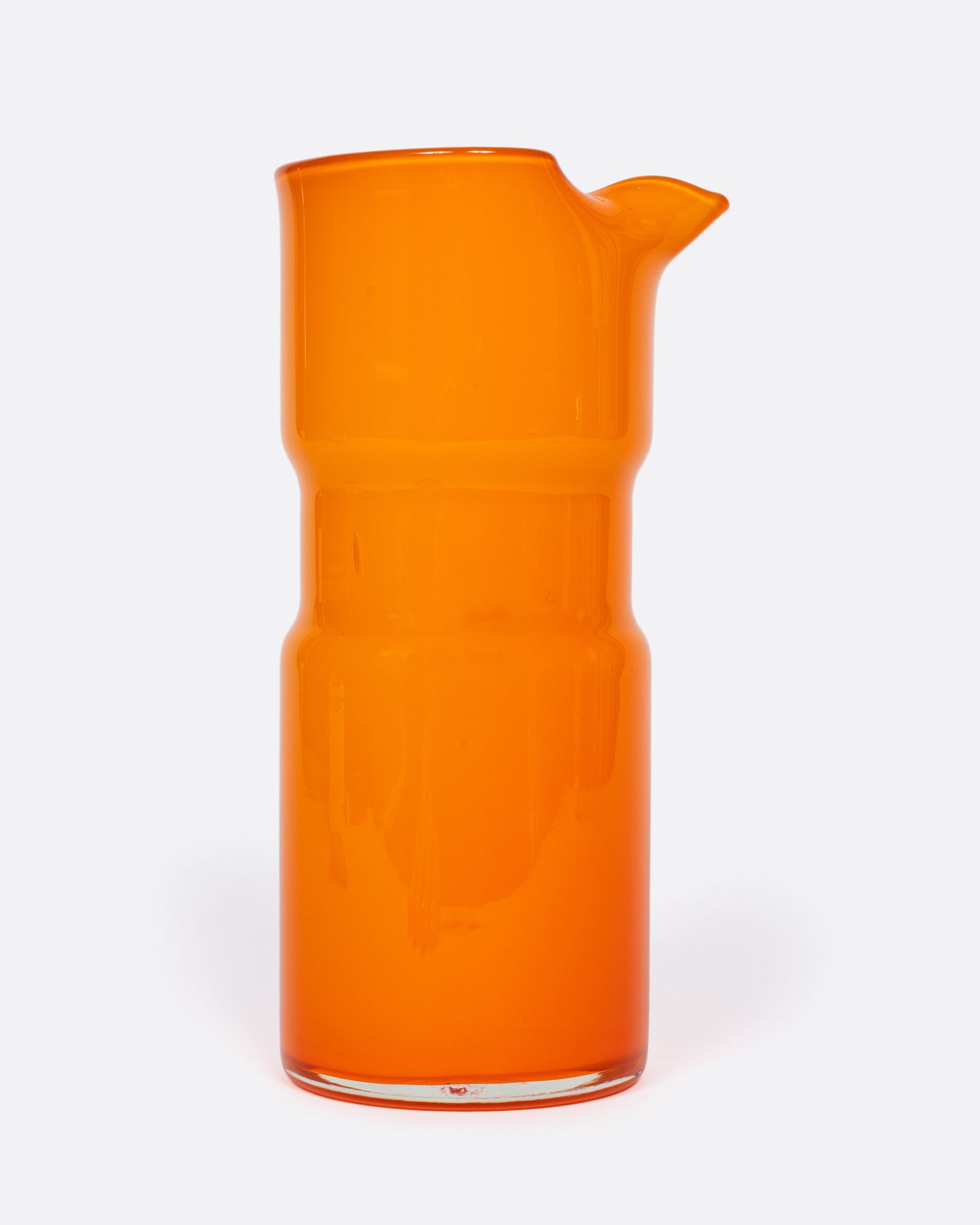 A citrus orange vintage cased glass pitcher made by layering orange glass over over white glass. It's the perfect splash of color for your summer tablescape.