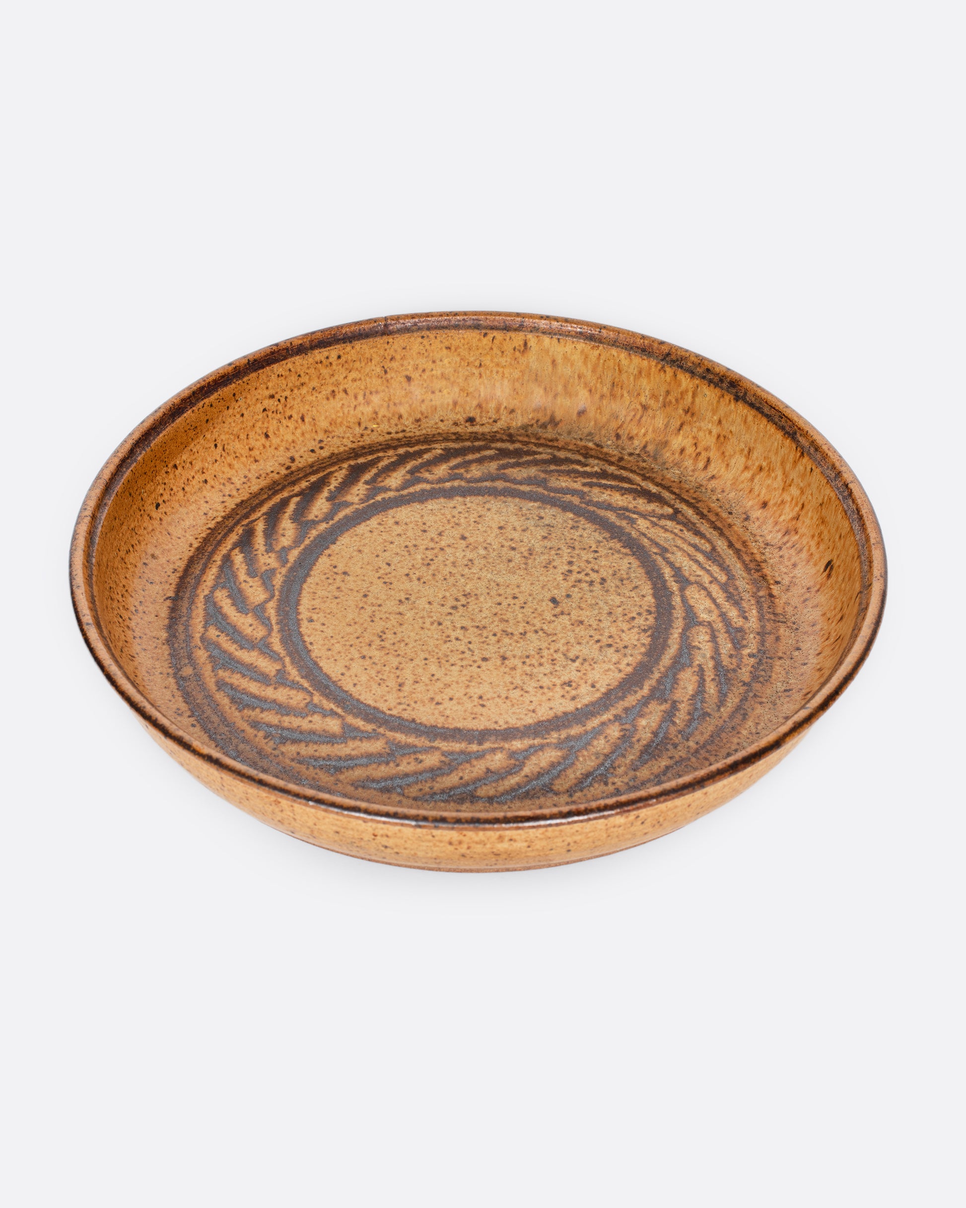 A vintage studio-made ceramic serving platter of generous size, with a swirling center design.