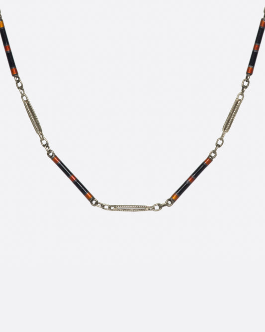 A vintage white gold bar-link chain necklace dotted with red and black enamel—a subtle pop of color for someone with a minimalist sensibility.