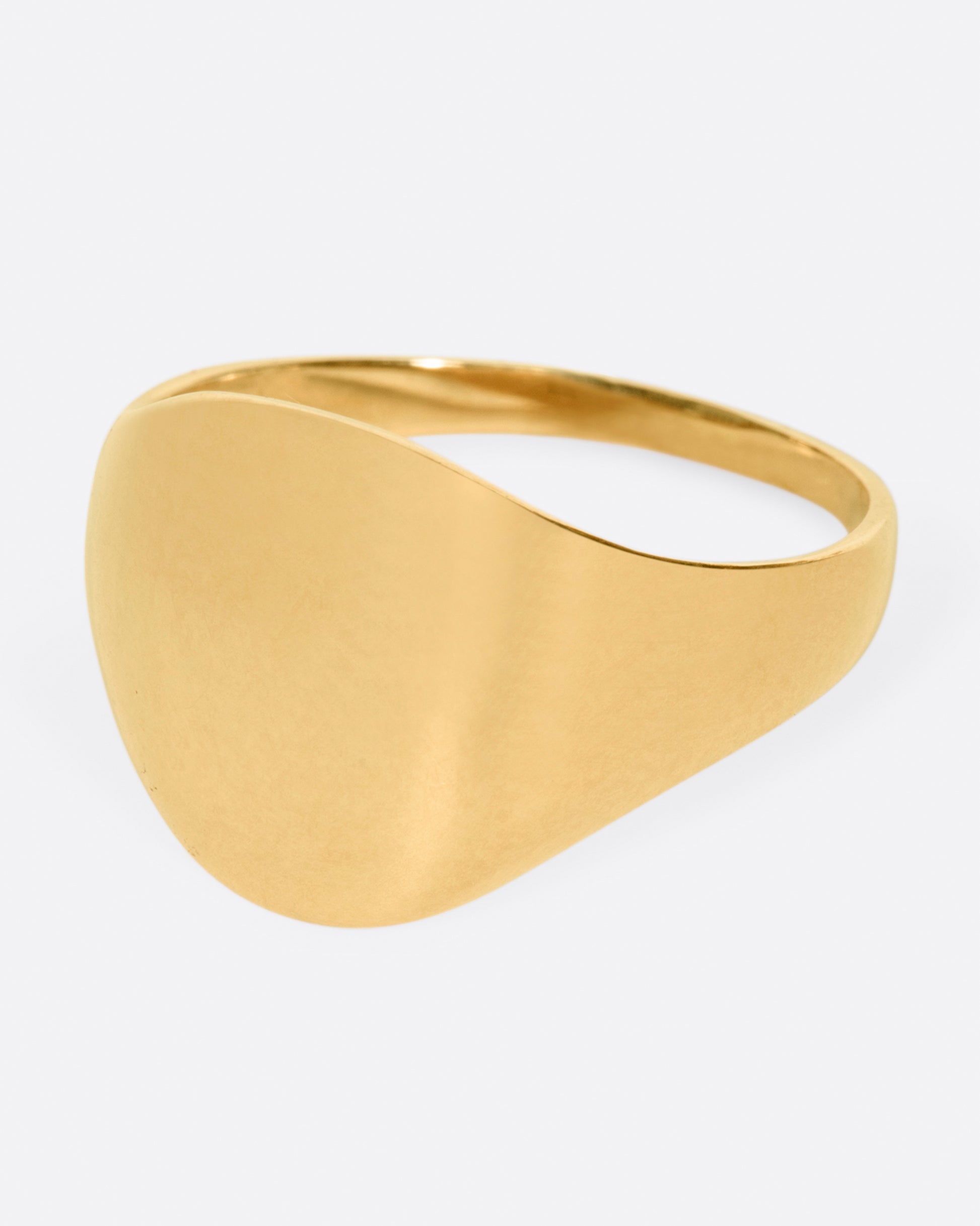 A vintage yellow gold signet ring with a round face and soft shoulders.