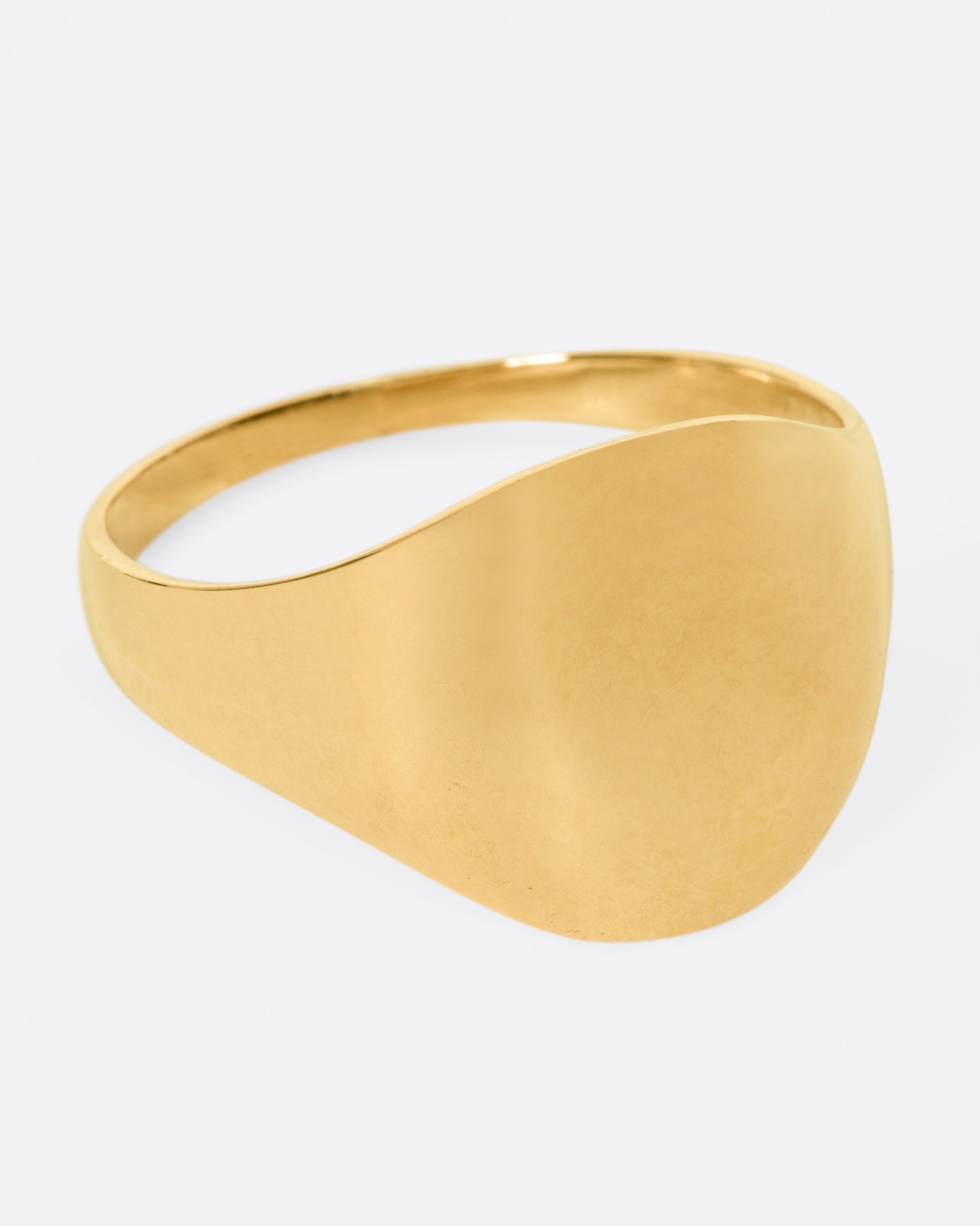 A vintage yellow gold signet ring with a round face and soft shoulders.