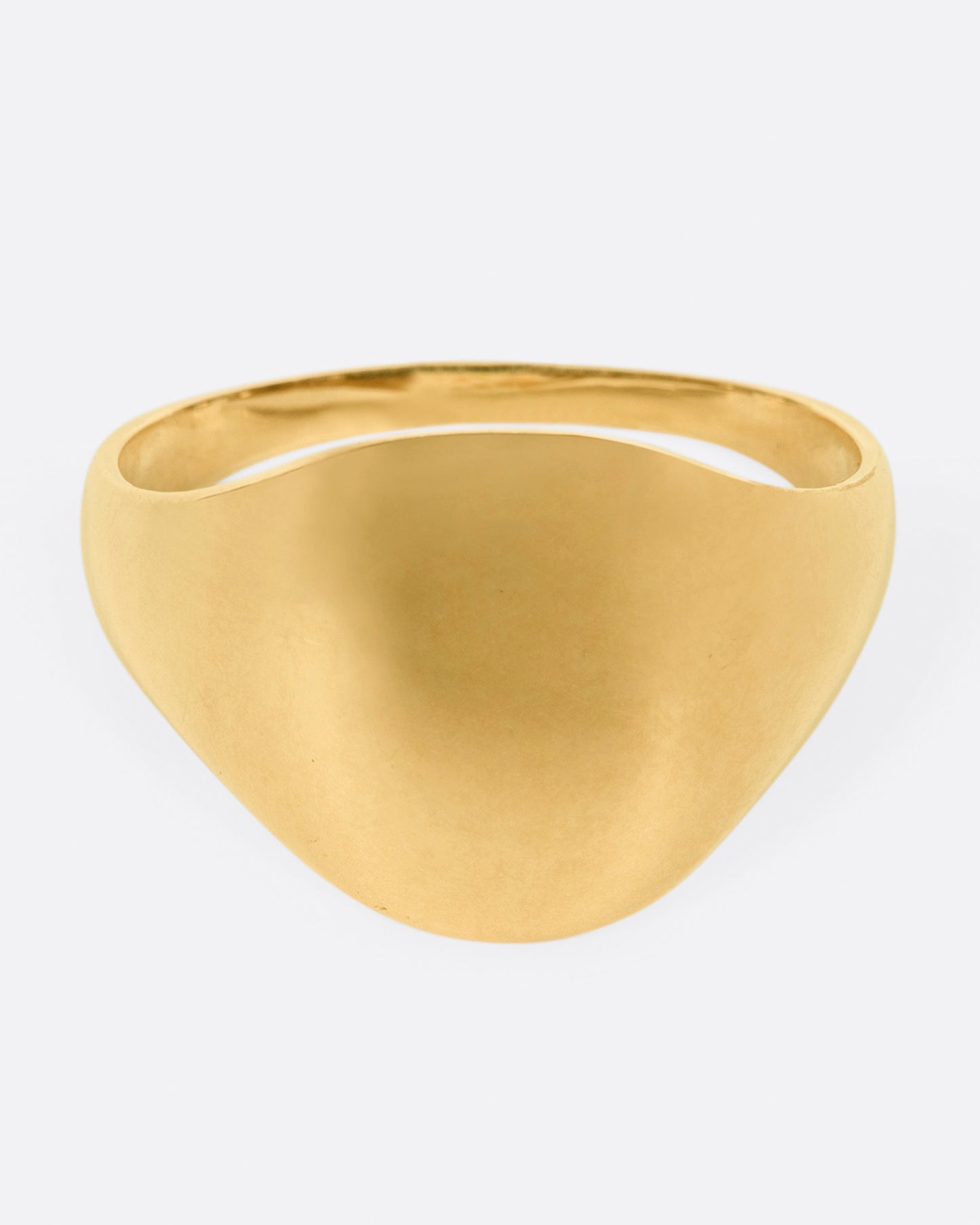 A vintage yellow gold signet ring with a round face and soft shoulders.