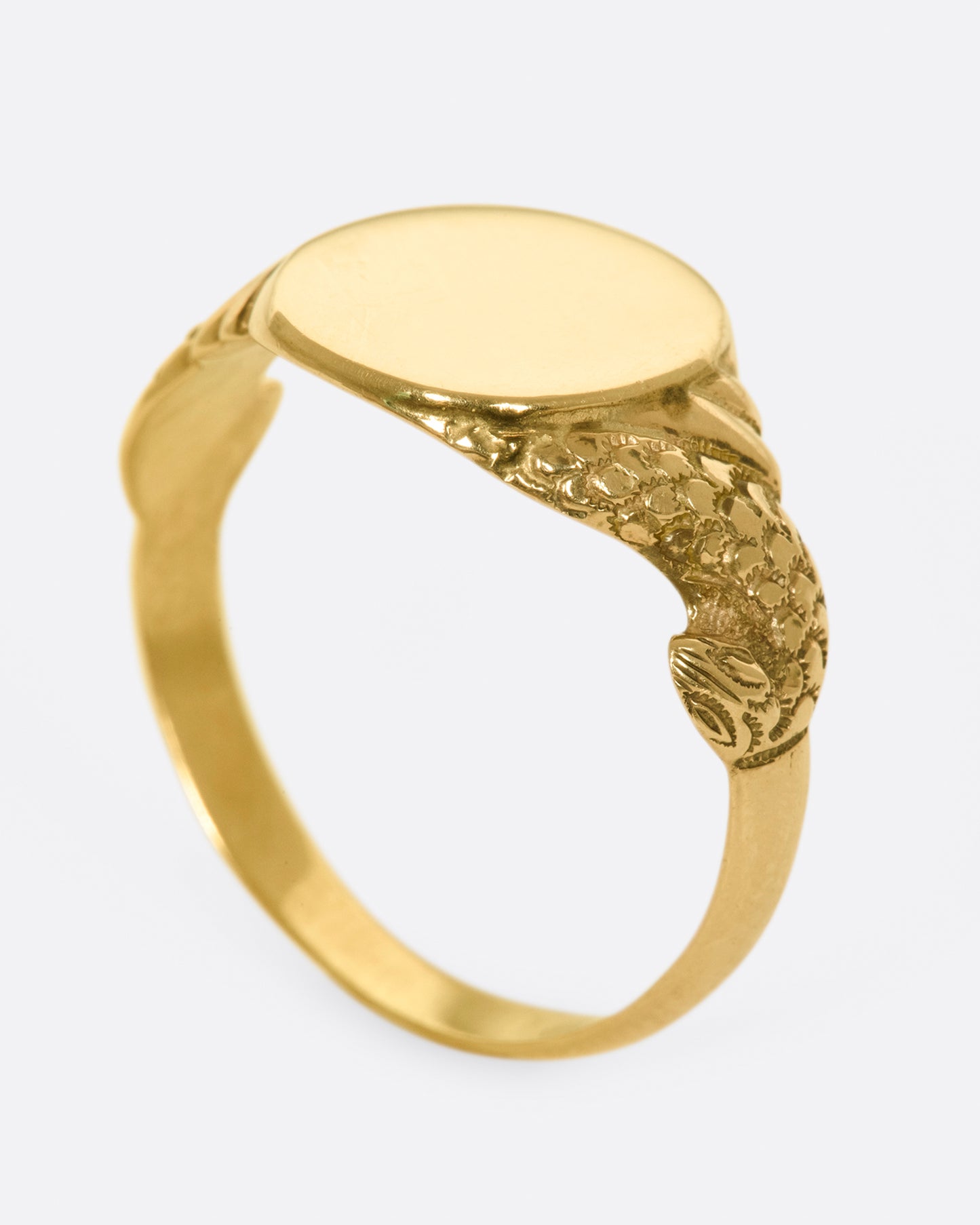 A classic, blank signet ring with carved snakes swirling around the band.