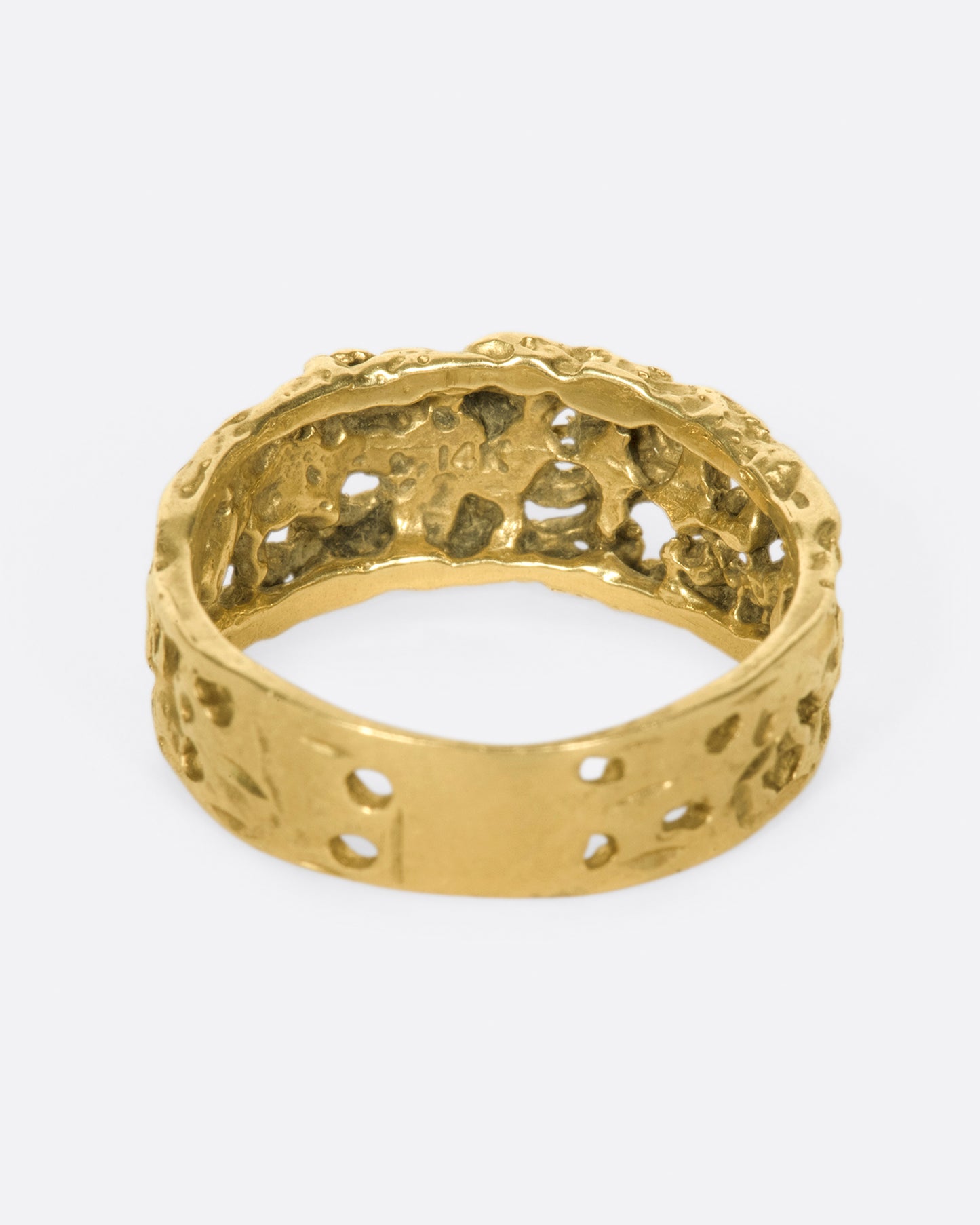 The cutouts on this ring almost look like the gold has eroded away, leaving little windows.