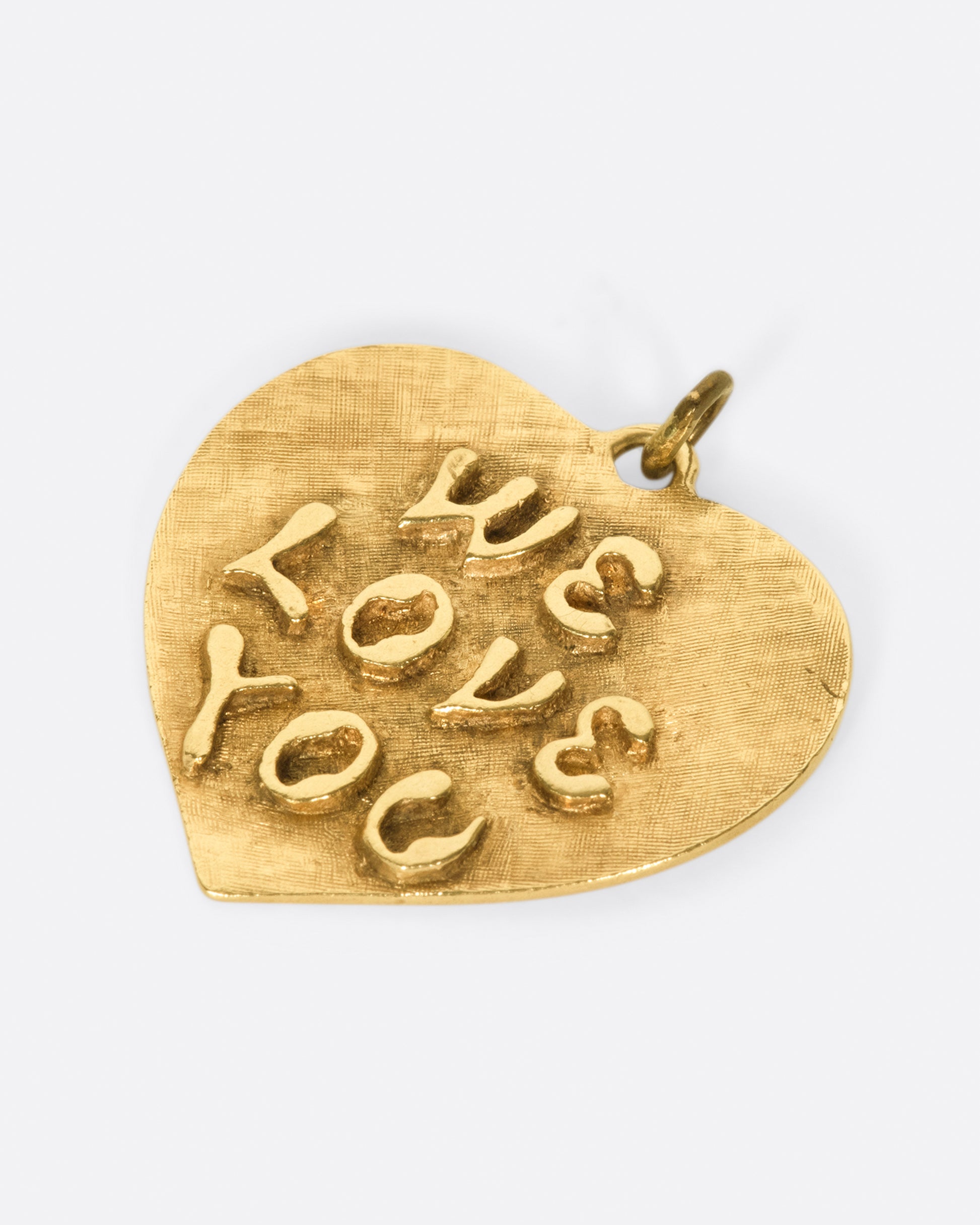 A large, textured heart tag with sweet sentiments on either side.