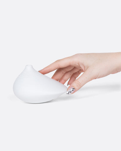 Vintage white porcelain bud vase, held in a hand for scale